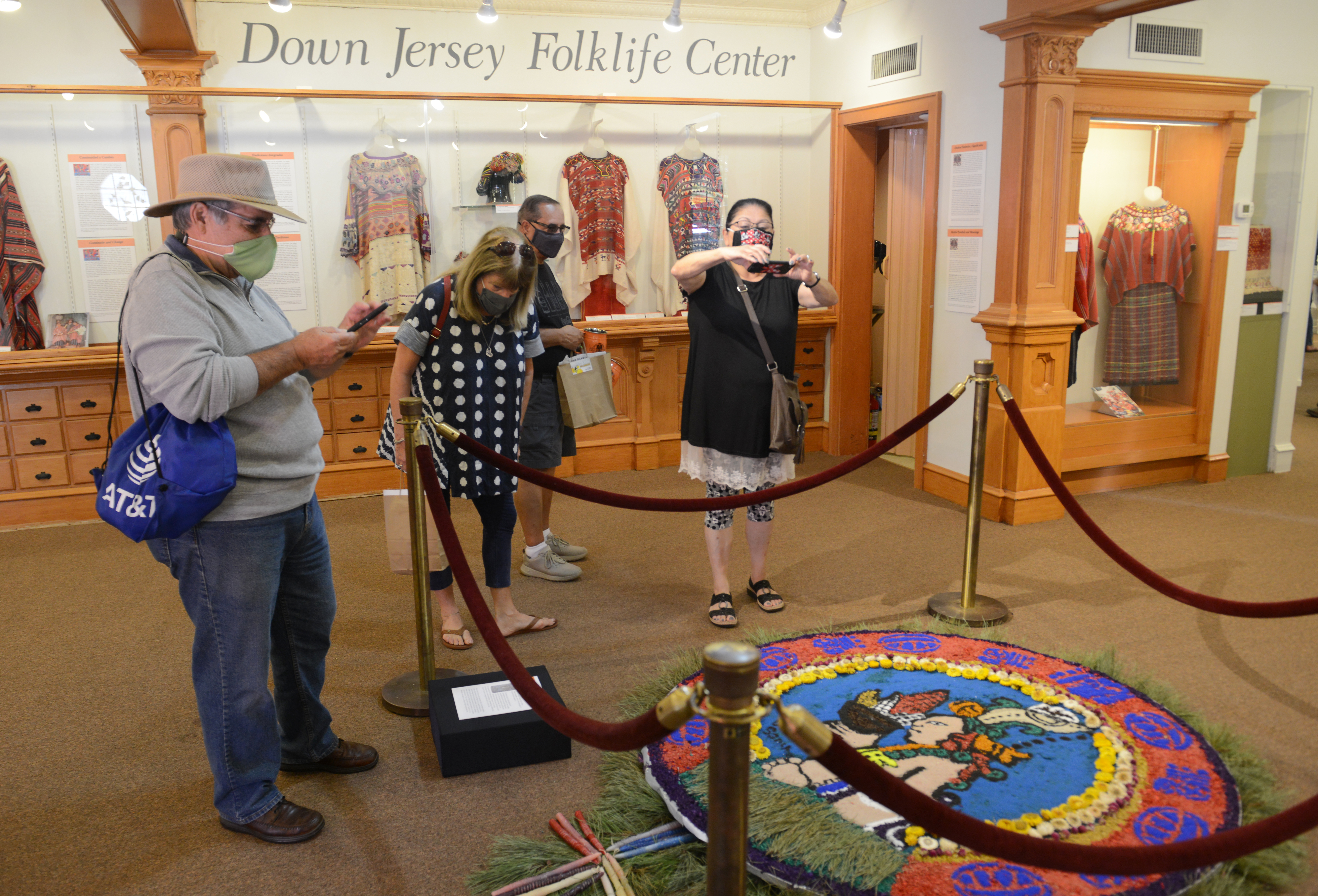 Spectators take pictures of a sawdust carpet on display inside the Down Jersey Folklife Center during the 22nd annual Festival of Fine Craft at Wheaton Arts in Millville, Saturday, Oct. 2, 2021.