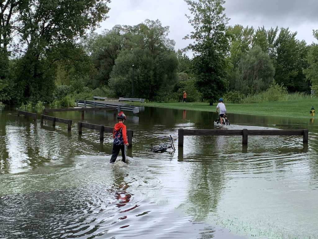 Two boys make their way through flooding on Shoveler Lane in Clay on Thursday, Aug. 19, 2021. Willow Stream overflowed during heavy rains, causing the closure of Shoveler Lane, between Canvasback Drive and Pintail Path. Rick Moriarty