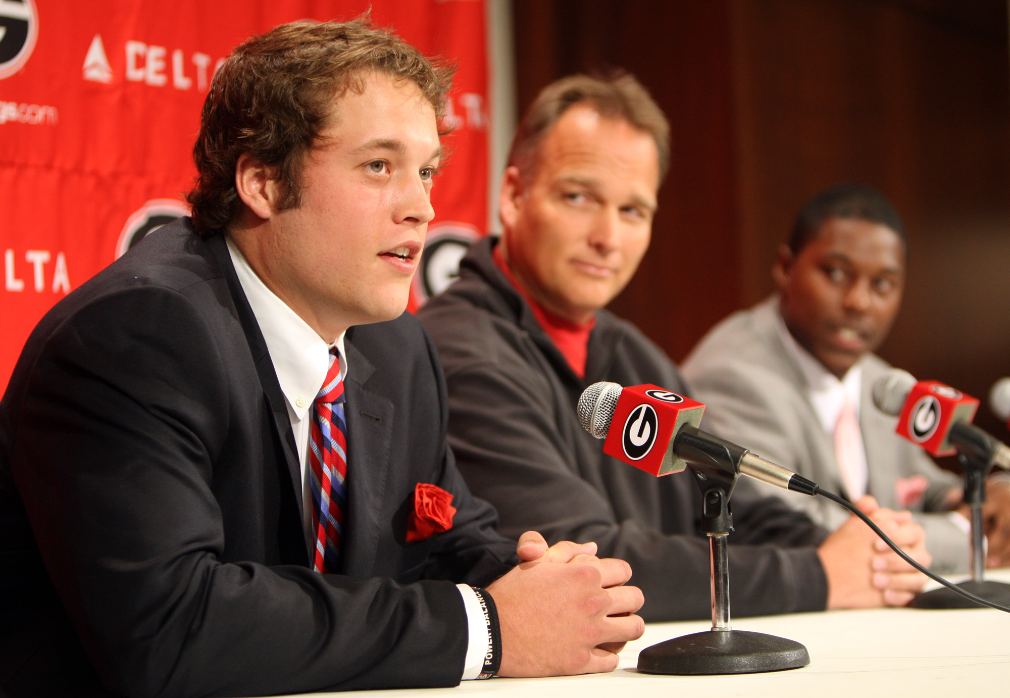 Georgia quarterback Matthew Stafford walks down an isle holding a