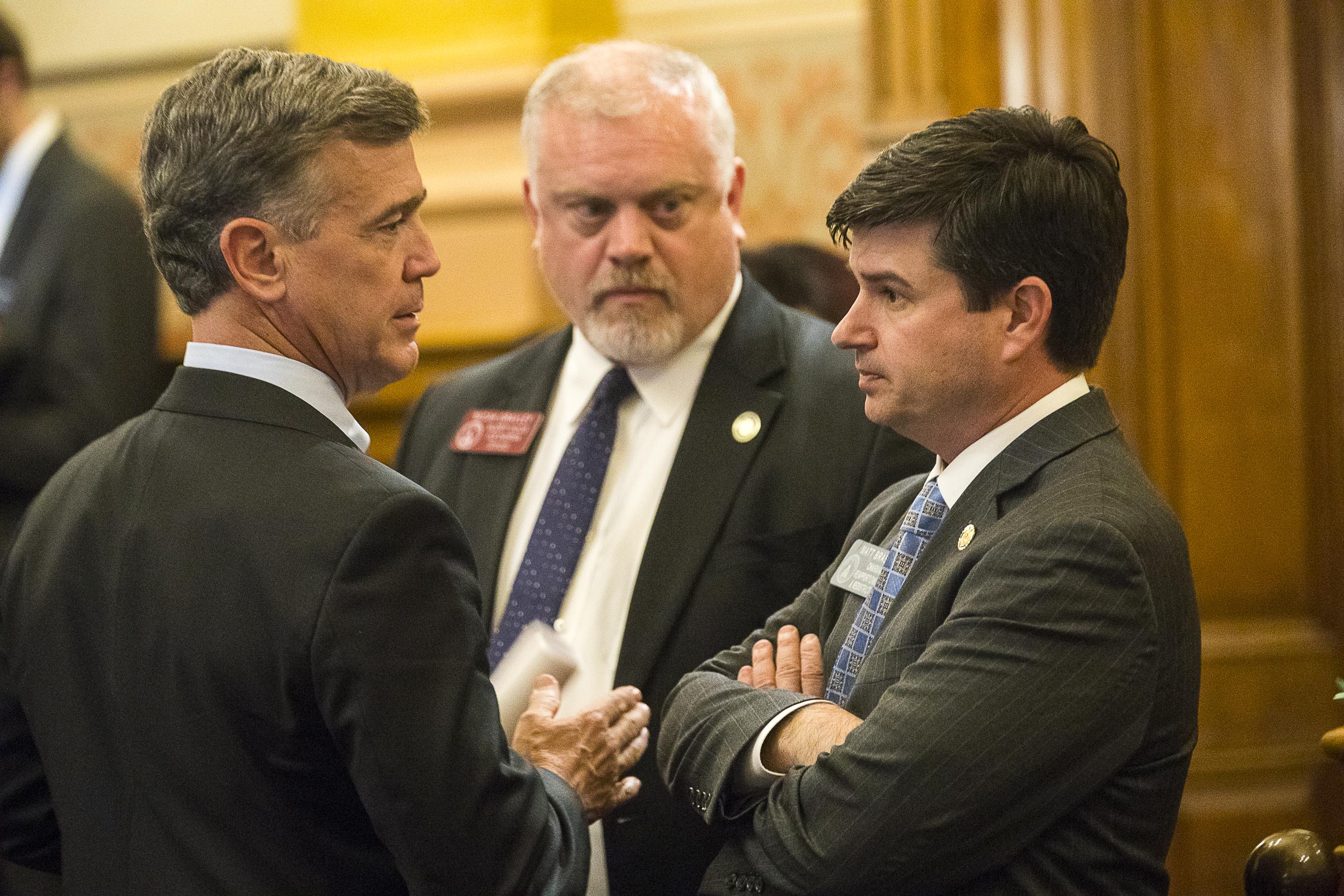 ATLANTA — Georgia Rep. Micah Gravley (center), sponsor of HB 324, looks on as state Rep. Mark Newton (left) speaks with state Sen. Matt Brass (right) in the Senate Chambers on April 2, 2019, the last day of the 2019 legislative session. Sen. Brass carried HB 324, the medical marijuana bill, in the Senate for Gravley. (ALYSSA POINTER/Alyssa.Pointer@AJC.com)