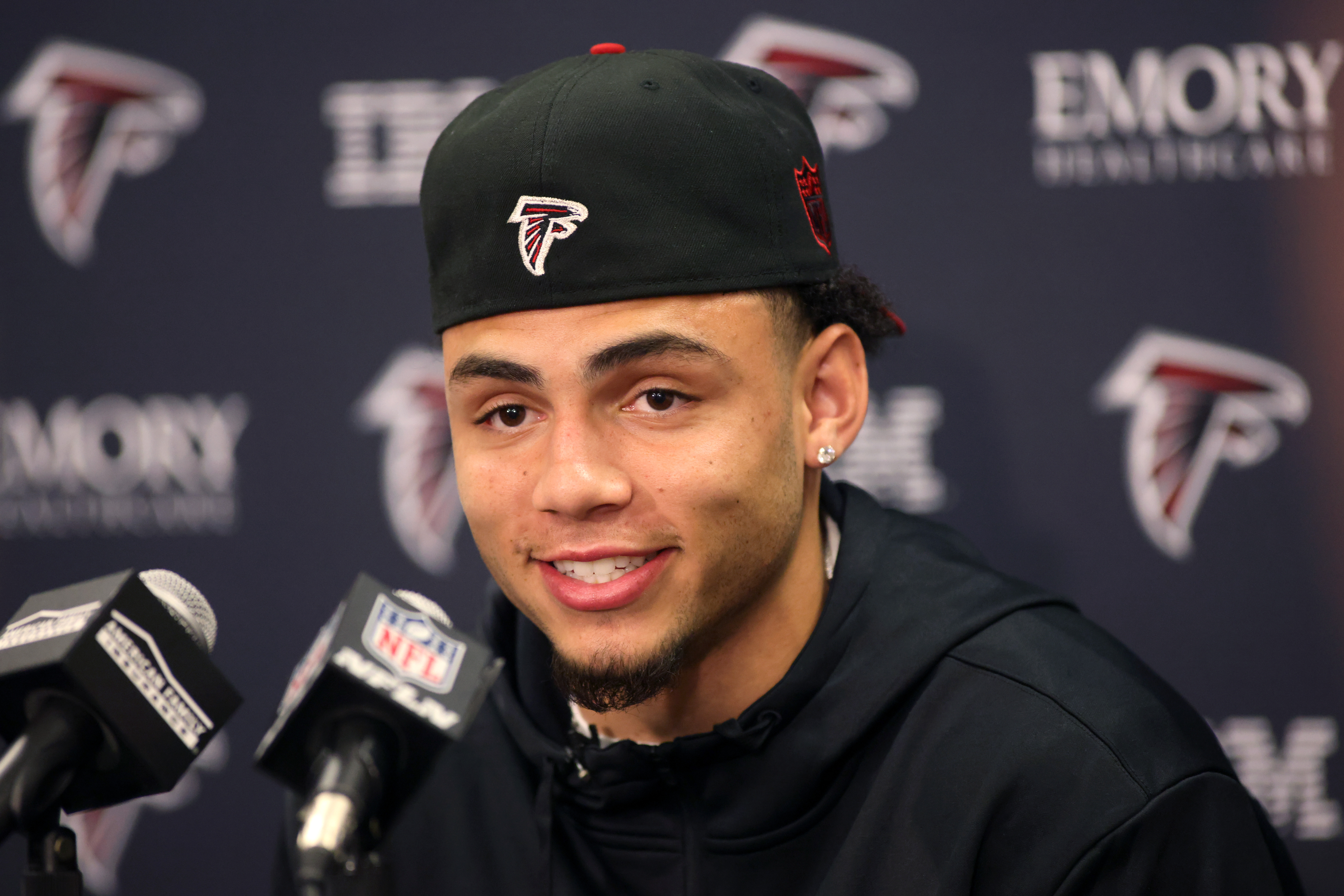 Atlanta Falcons first-round NFL football draft pick Drake London, center, a  wide receiver from USC, holds up his jersey with general manager Terry  Fontenot, left, and head coach Arthur Smith, right, at