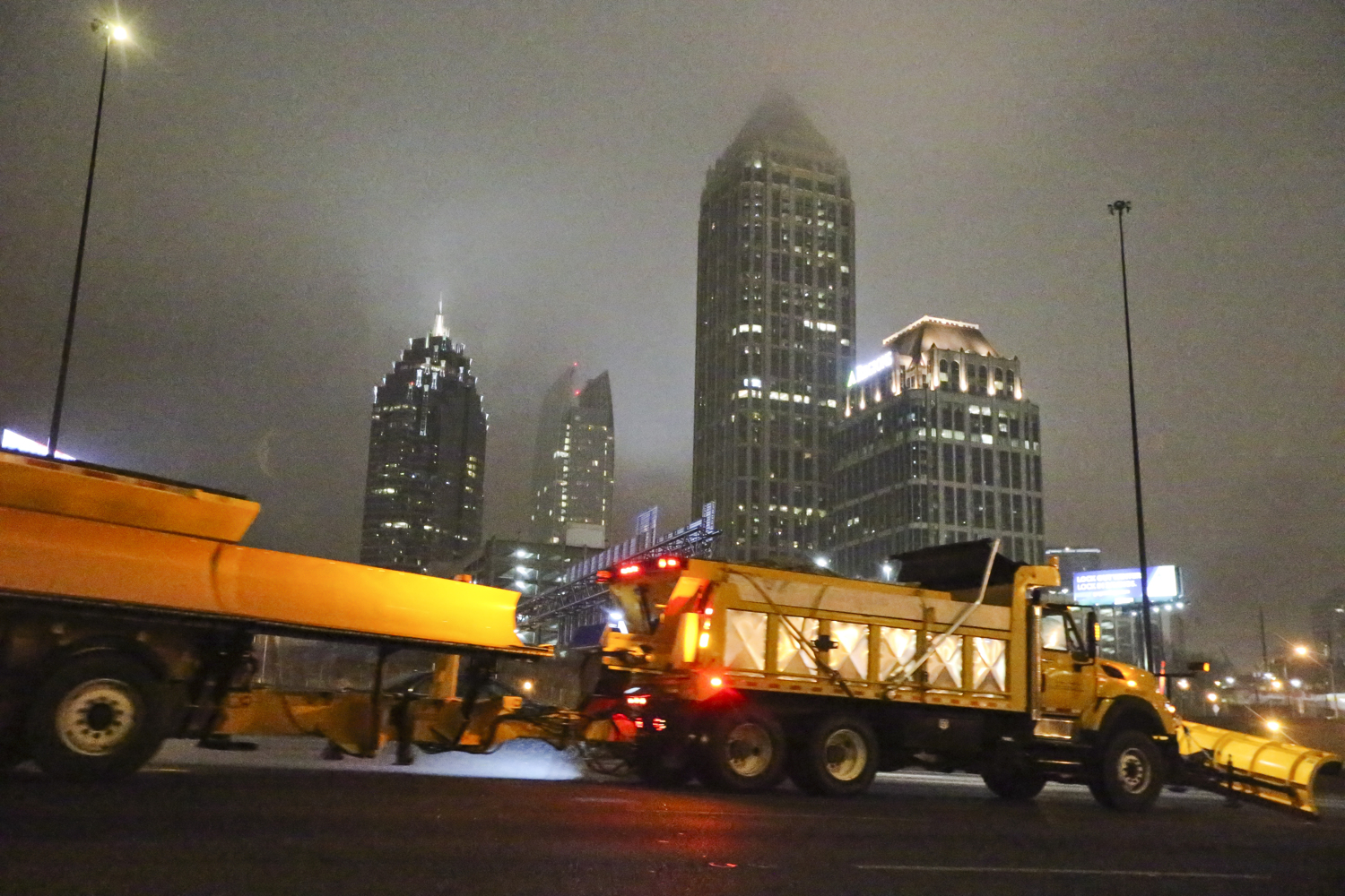 CLEARING ROADS--February 17, 2015 Atlanta: GDOT crews spread their winter mix across the southbound connector just after 17th Street on Tuesday, Feb. 17, 2015. Officials closed their emergency operations center Tuesday after the threat of ice on metro Atlanta’s interstates and state routes no longer posed a danger to travelers “Everything looks good, roads are clear,” said Natalie Dale, a spokeswoman for the Georgia Department of Transportation. “We were really fortunate given the amount of rain we got and the dropping temperatures that we were able to keep the roads free of ice. We had a relatively incident-free morning.” The gusty winds were a double-edged sword, helping to dry up wet patches on roads but knocking down ice-laden trees and power lines, especially in northeast Georgia. Metro Atlanta was largely spared from dire predictions of black ice, with just a few icy spots that were quickly remedied. No major accidents occurred. About 188,000 customers lost power in North Georgia between the state’s largest utility, Georgia Power, and Georgia’s Electric Membership Cooperatives, according to data released at about 9:45 a.m. JOHN SPINK/JSPINK@AJC.COM