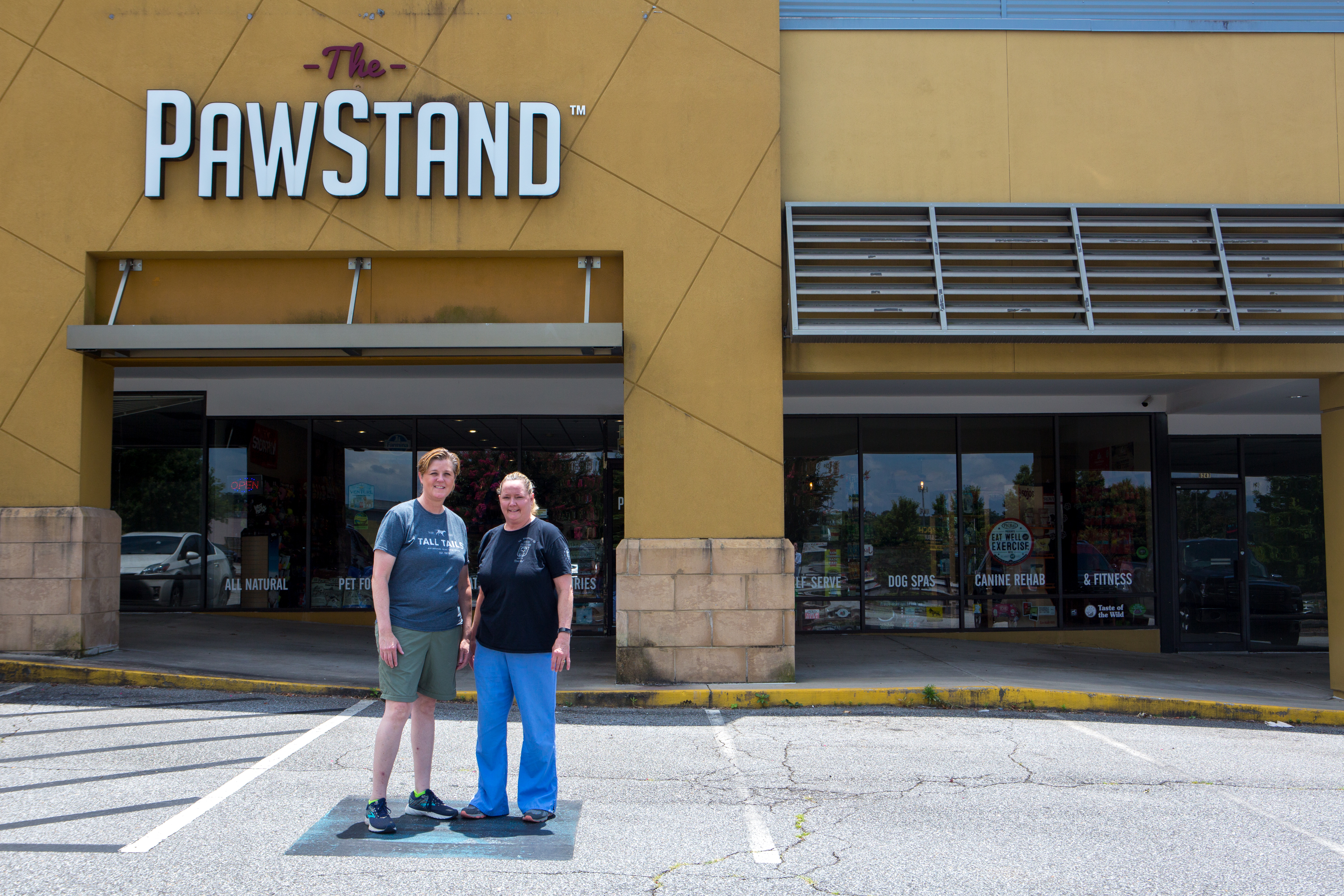 Co-owners Donna Raney (left) and Jennifer Andreae stand in front of their business, The PawStand, in Doraville. They have concerns that the parking spaces directly outside their store could be taken away following the development at the center. (Casey Sykes for The Atlanta Journal-Constitution)