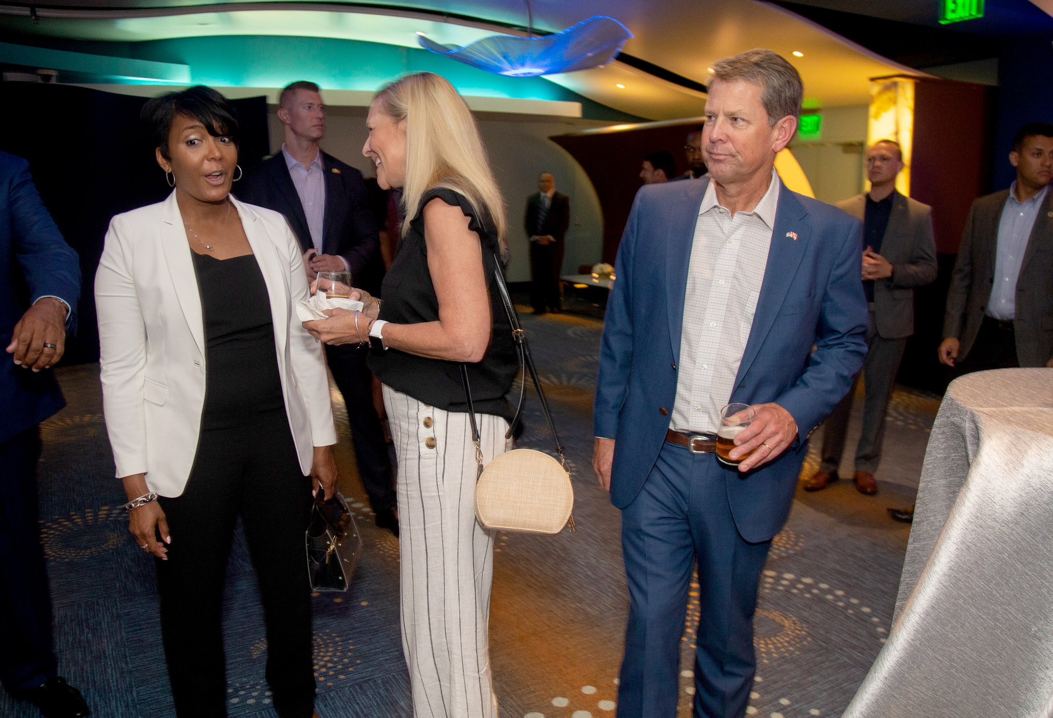 Mayor of Atlanta Keisha Lance Bottoms (left) and Georgia Governor Brian Kemp (right) talk with others before the start of Bernie Marcus’s 90th birthday party and fundraiser at the Georgia Aquarium on Sunday.