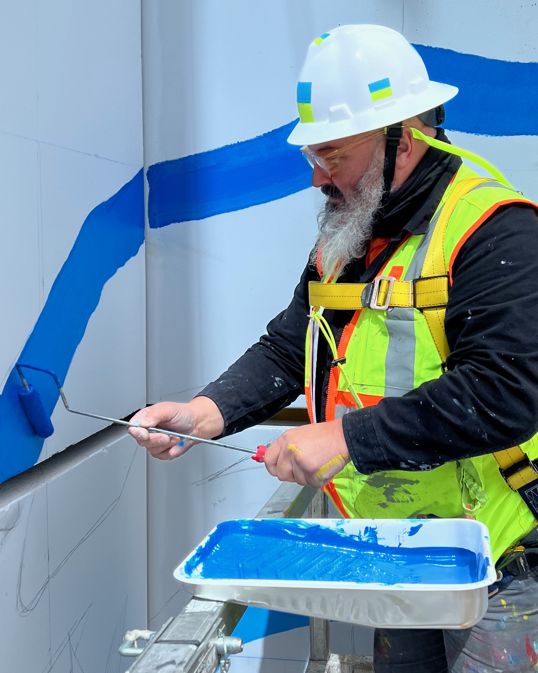 Joe Dreher works on the mural on the side of the Midtown Union building.