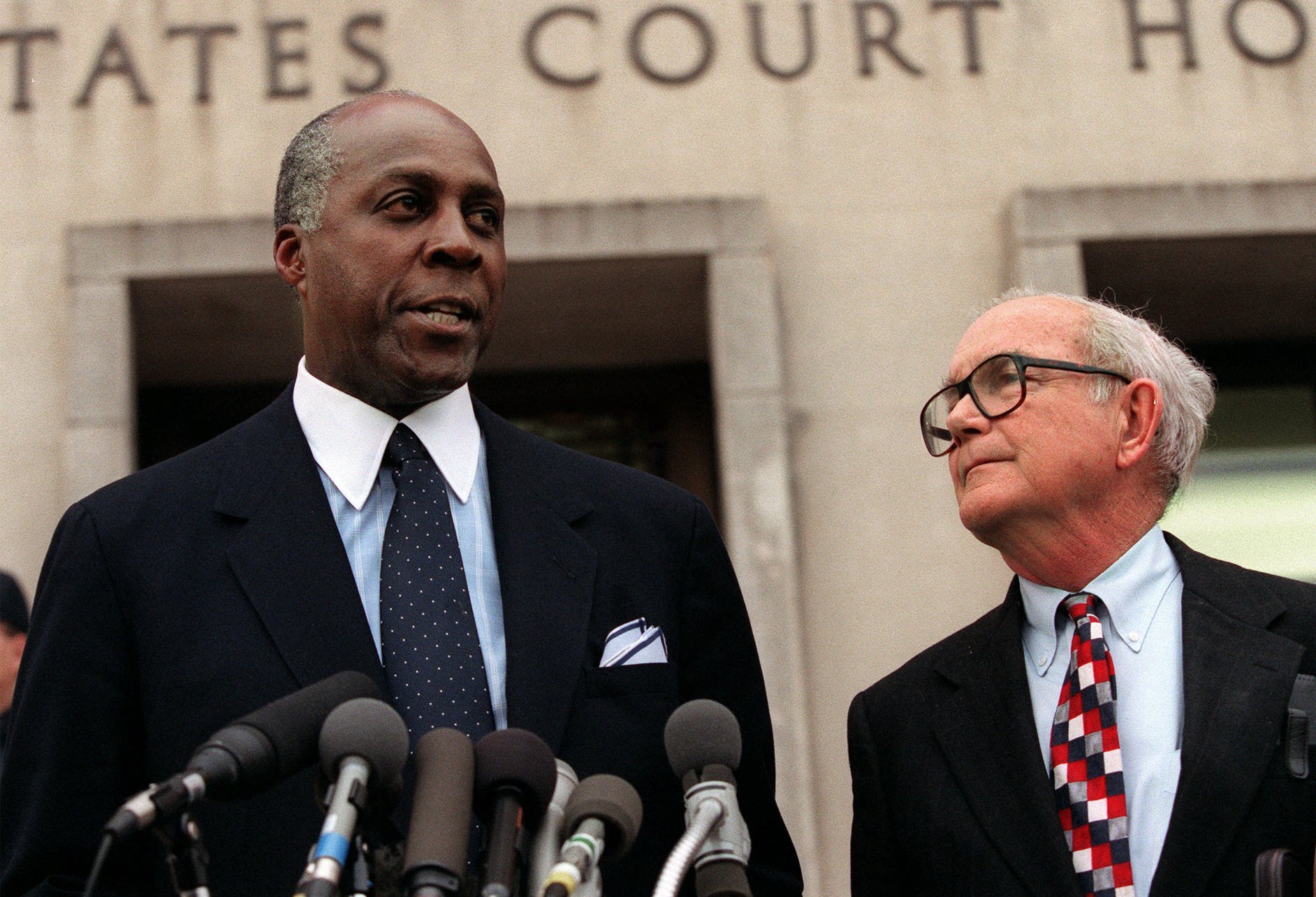 Vernon Jordan, accompanied by attorney William Hundley, meets with reporters outside federal court in Washington in 1998.