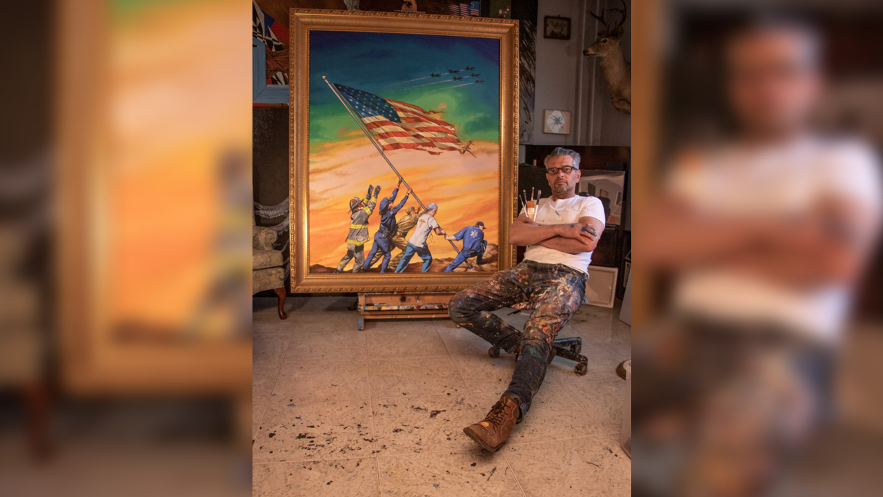 Artist Scott LoBaido poses next to his print, “Sunrise: A Tribute to First Responders.”