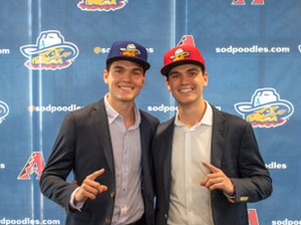 Twin brothers Stefan Caray (left, in blue cap) and Chris Caray (right, in red cap) after a press conference introducing them as the broadcasters for the Amarillo Sod Poodles minor-league baseball team. (Photo by Isaac Galan / Special to the AJC)
