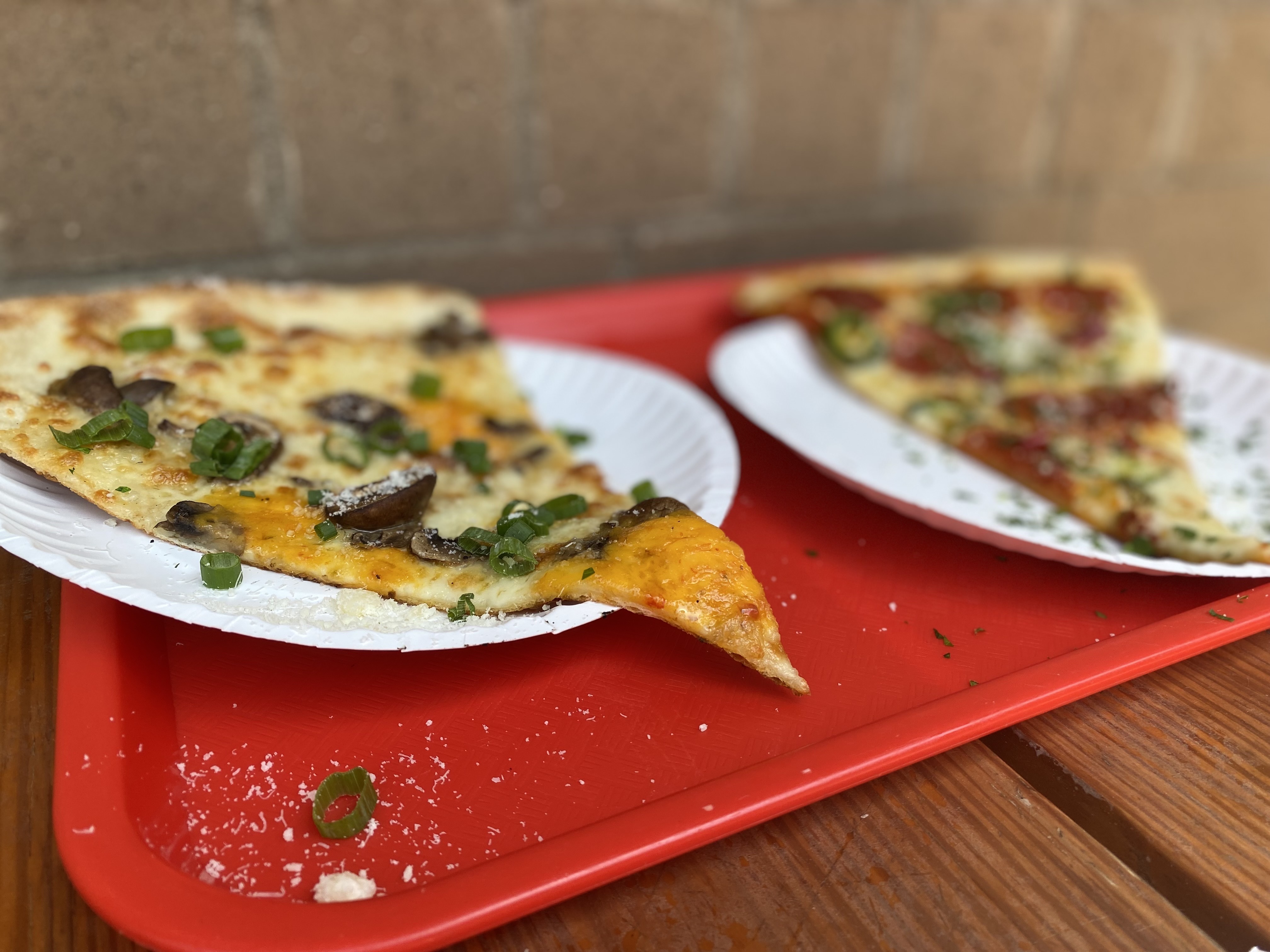 Old Fourth Ward pizzeria Glide sells slices of its massive 20-inch Brooklyn-style pies, including the Homegrown (left) featuring pimento cheese. Ligaya Figueras / ligaya.figueras@ajc.com