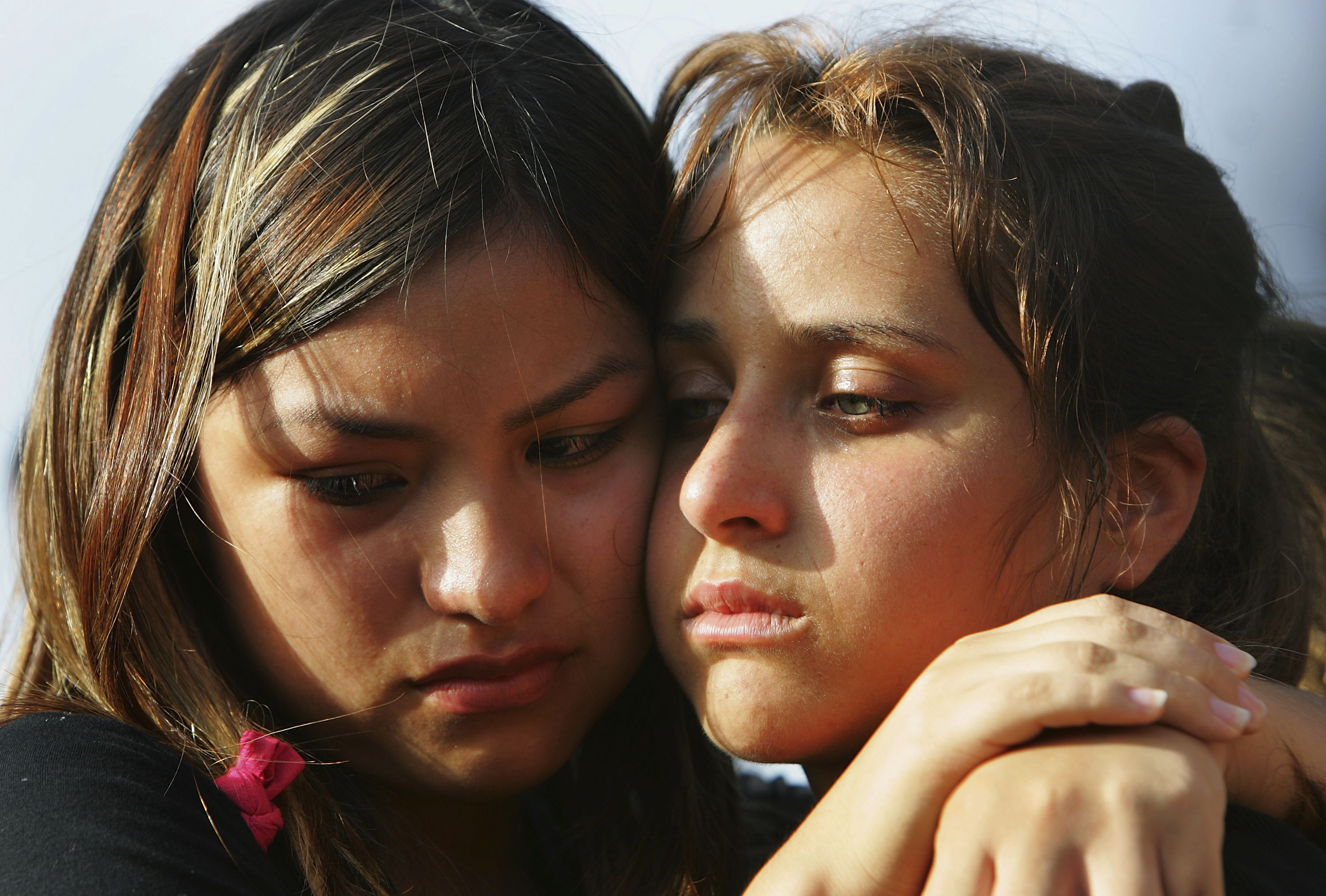 TEL AVIV, ISRAEL - JULY 13: Schoolfriends of 16-year-old Israeli teenager girls Nofar Horvitz and Rachel Ben Abu comfort each other as they grieve over their adjoining graves during her funeral July 13, 2005 at Tel Aviv's Yarkon cemetery, Israel. The childhood friends were two of the four victims of a Palestinian suicide bombing in the Israeli town of Netanya the previous evening and were buried in adjacent graves in a joint funeral. (Photo by David Silverman/Getty Images)