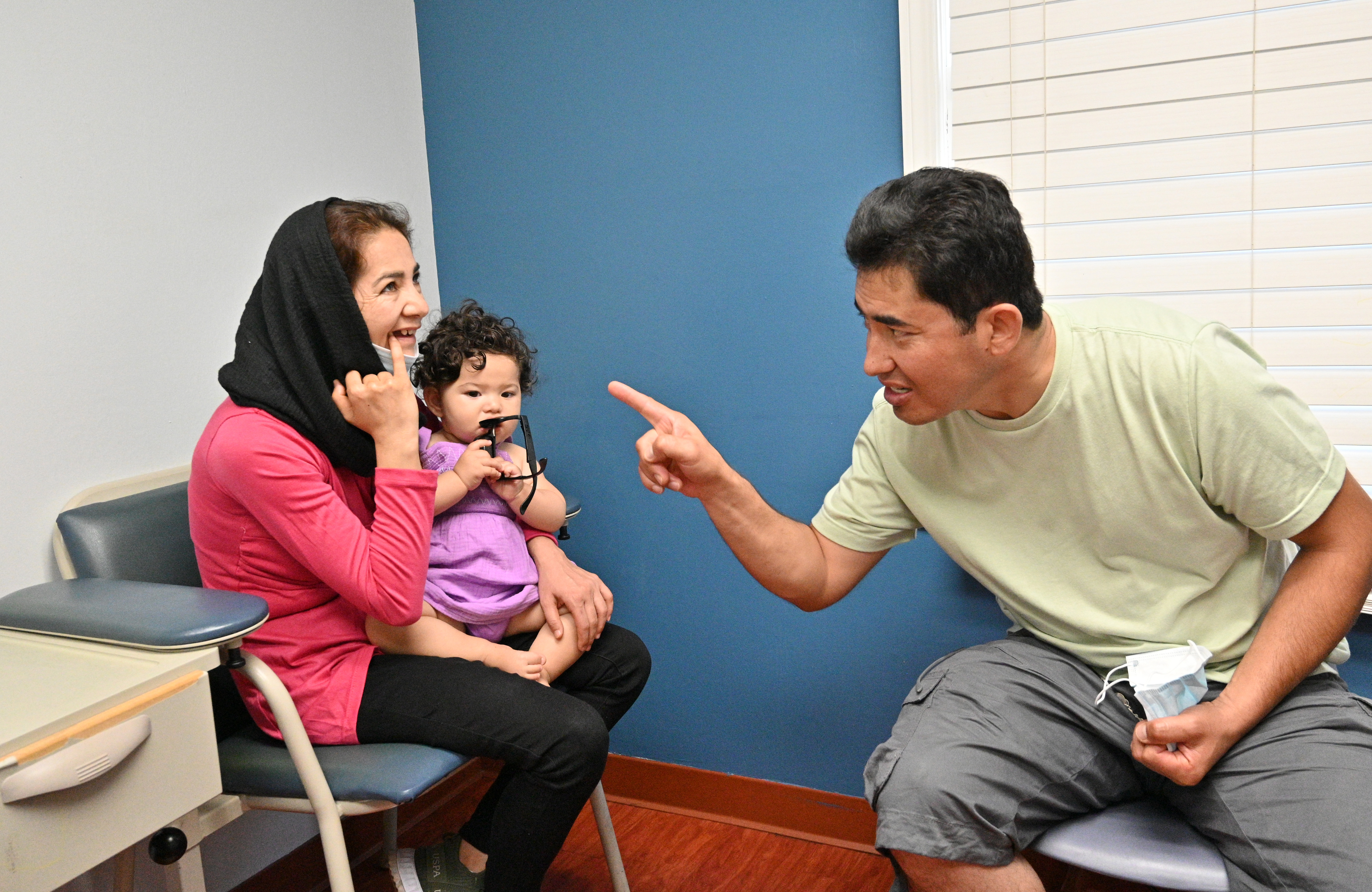 June 24, 2022 Clarkston - Ahmad Farid Frotan (right) explains the need of dental care for him and his wife Rahima Rahimi as she holds their 1-year-old daughter Sosan at Ethne Health Clinic in Clarkston on Friday, June 24, 2022. The medical practitioners at Ethne Health, a Clarkston community clinic, say many of their patients suffer from oral health problems. They hope to one day be able to expand and start operating a dental center in the community. (Hyosub Shin / Hyosub.Shin@ajc.com)