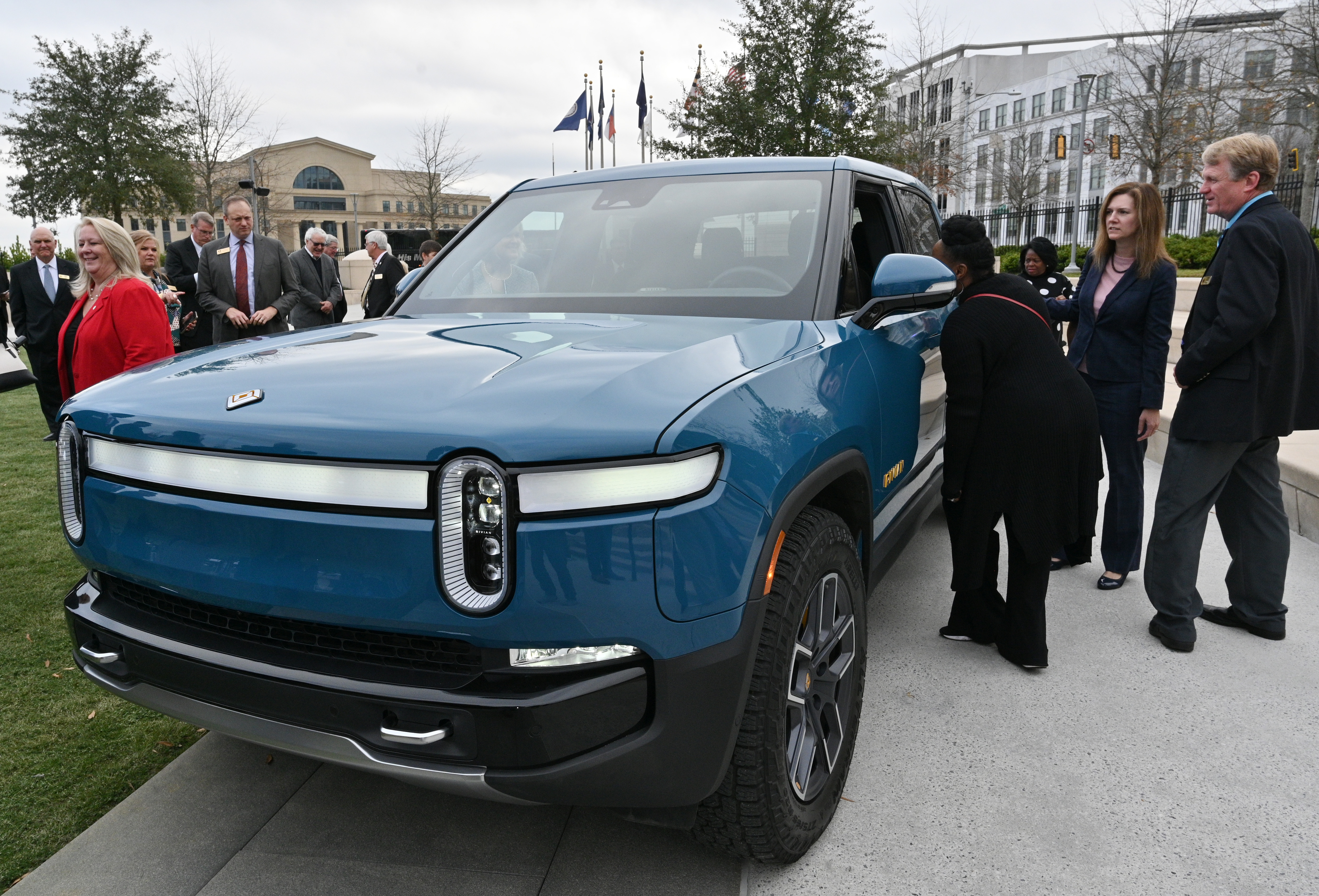 Guests look at Rivian's R1T electric truck during a press conference at Liberty Plaza across from the Georgia State Capitol in Atlanta on Thursday, December 16, 2021. Electric vehicle maker Rivian confirmed its plans to build a $5 billion assembly plant and battery factory in Georgia, which Gov. Brian Kemp called "the largest single economic development project ever in this state's history." (Hyosub Shin / Hyosub.Shin@ajc.com)