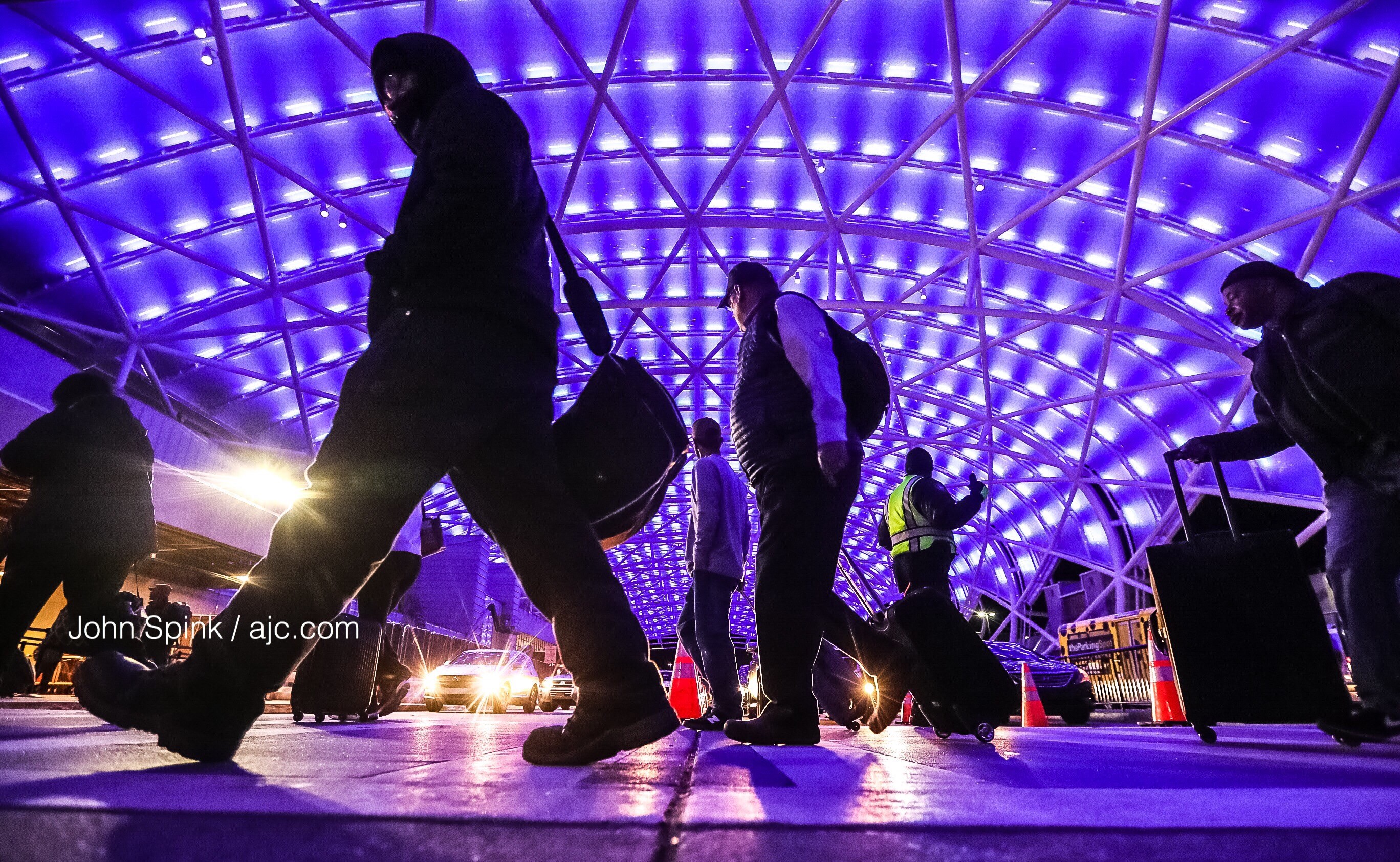 Morning commuters arrive in the cold and under a blue canopy at Hartsfield-Jackson International Airport (ATL) Friday. At midnight, 1800 LED lights on the airport's north canopy will turn blue and burn brightly to commemorate National Human Trafficking Awareness Day. The blue lights will symbolize ATL's commitment to stamping out sexual exploitation and other forms of human trafficking. JOHN SPINK / JSPINK@AJC.COM