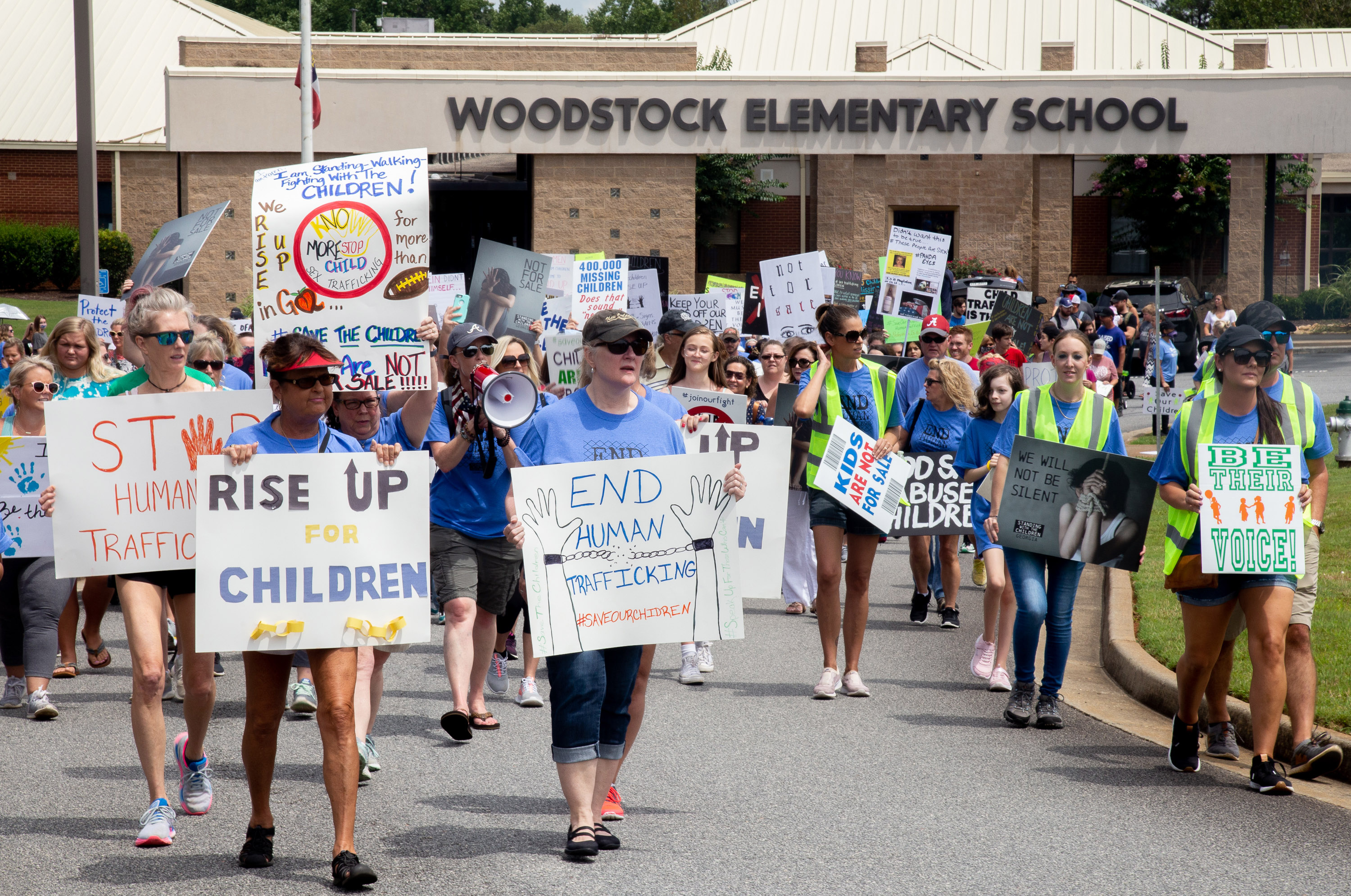 Standing with the Children protesters head out from Woodstock Elementary on their way to the Elm Street Event Green in Woodstock Saturday, August 22, 2020. STEVE SCHAEFER FOR THE ATLANTA JOURNAL-CONSTITUTION