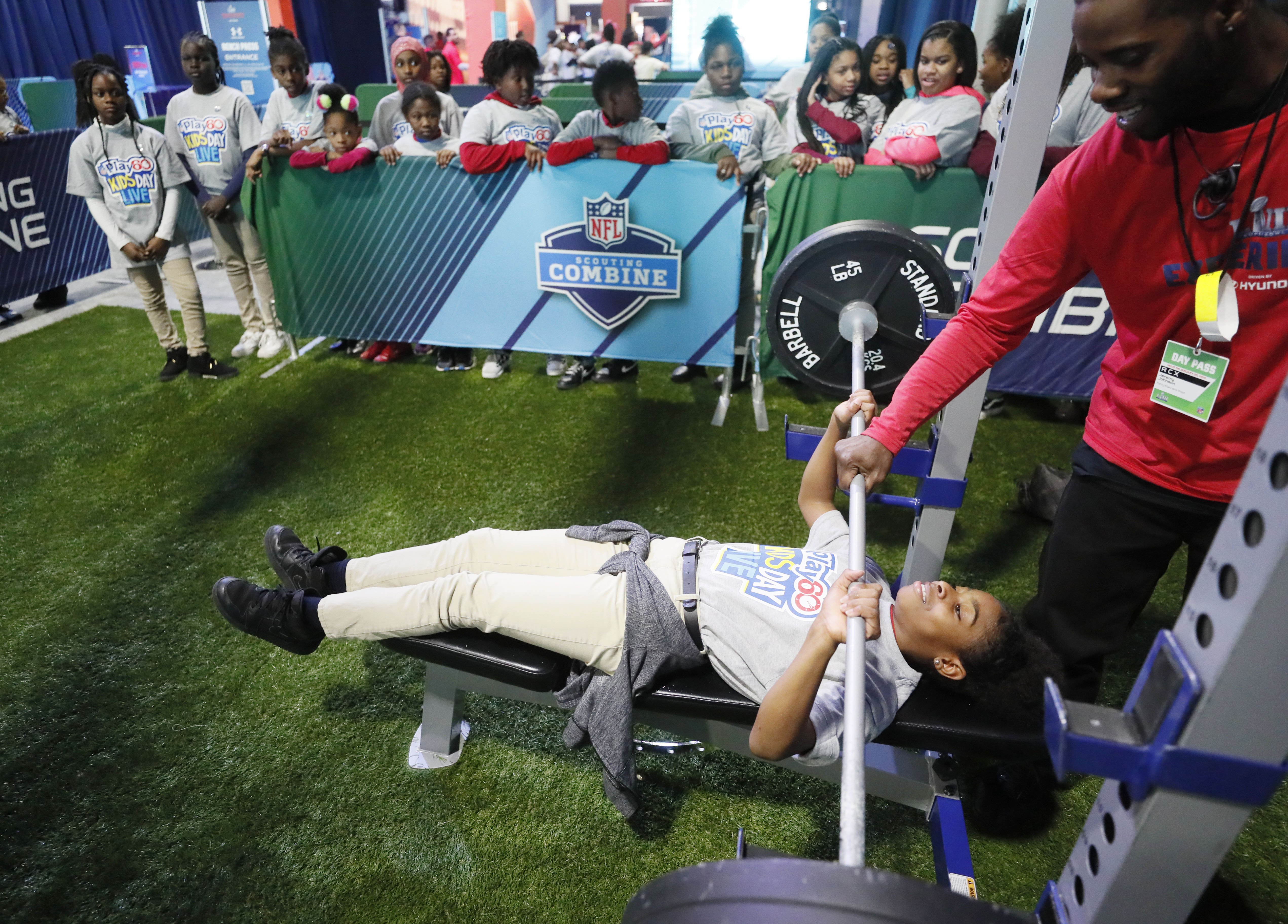 Erin Evans tries her hand at the bench press in the Scouting Combine attraction. NFL PLAY 60 Kids' Day gave more than 2,000 local youth to spend the day at the Super Bowl Experience. The kids were free to roam through the many attractions at the Georgia World Congress Center. (Bob Andres / bandres@ajc.com)