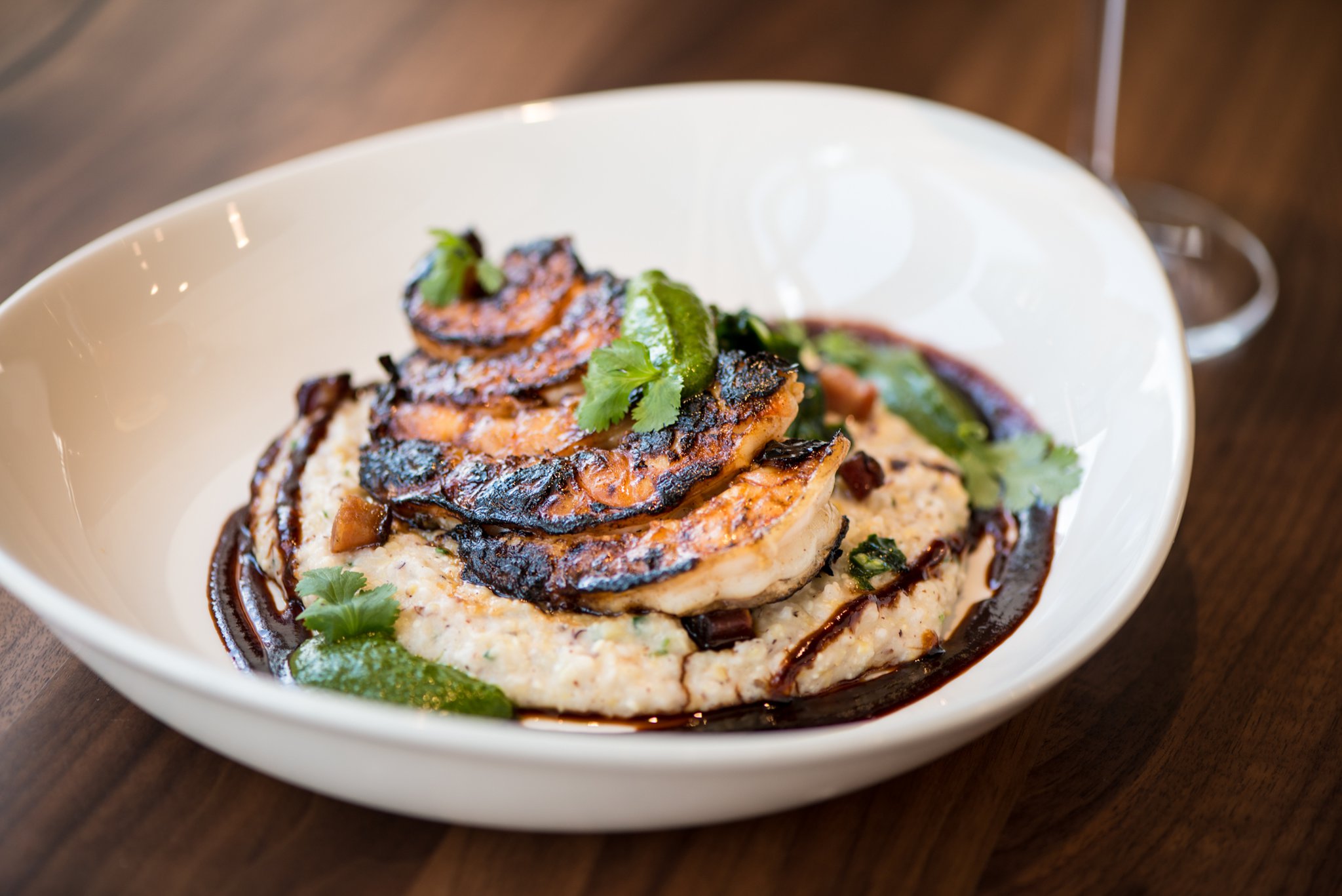 Harissa Shrimp and Grits with chermoula, aged cheddar, and kale. Photo credit- Mia Yakel.