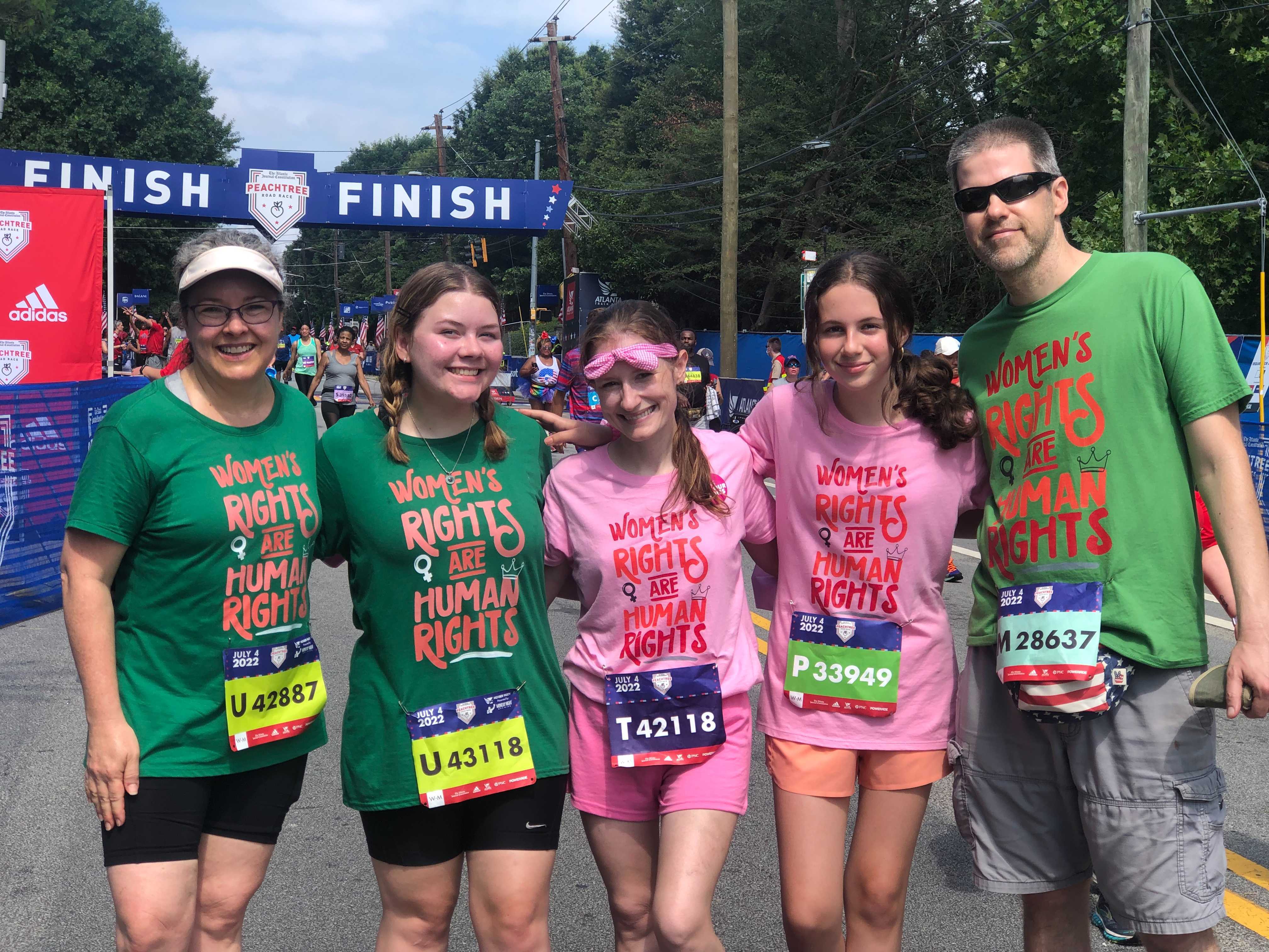 A group of family and friends wore matching T-shirts that say “Women’s rights are human rights” at the Atlanta Journal-Constitution Peachtree Road Race in Atlanta on Monday, July 4, 2022. Left to right: Sheri Hardin, 52; Ella Dawson, 18; Stephanie Hunter, 41; Jorien Flowers, 12; and Grant Flowers, 48.