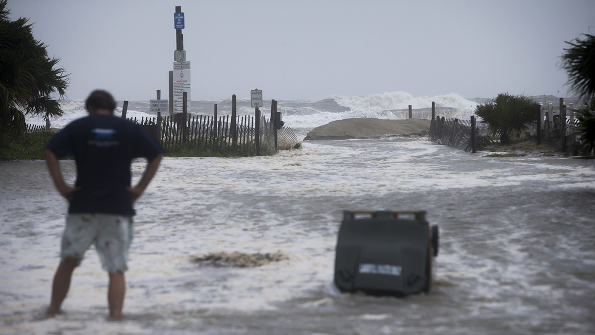 Part of a temporary berm put up to stop the storm surge from Tropical Storm Irma breaks apart and floods the street, Monday, Sept., 11, 2017 on of Tybee Island, Ga.  (AP Photo/Stephen B. Morton)