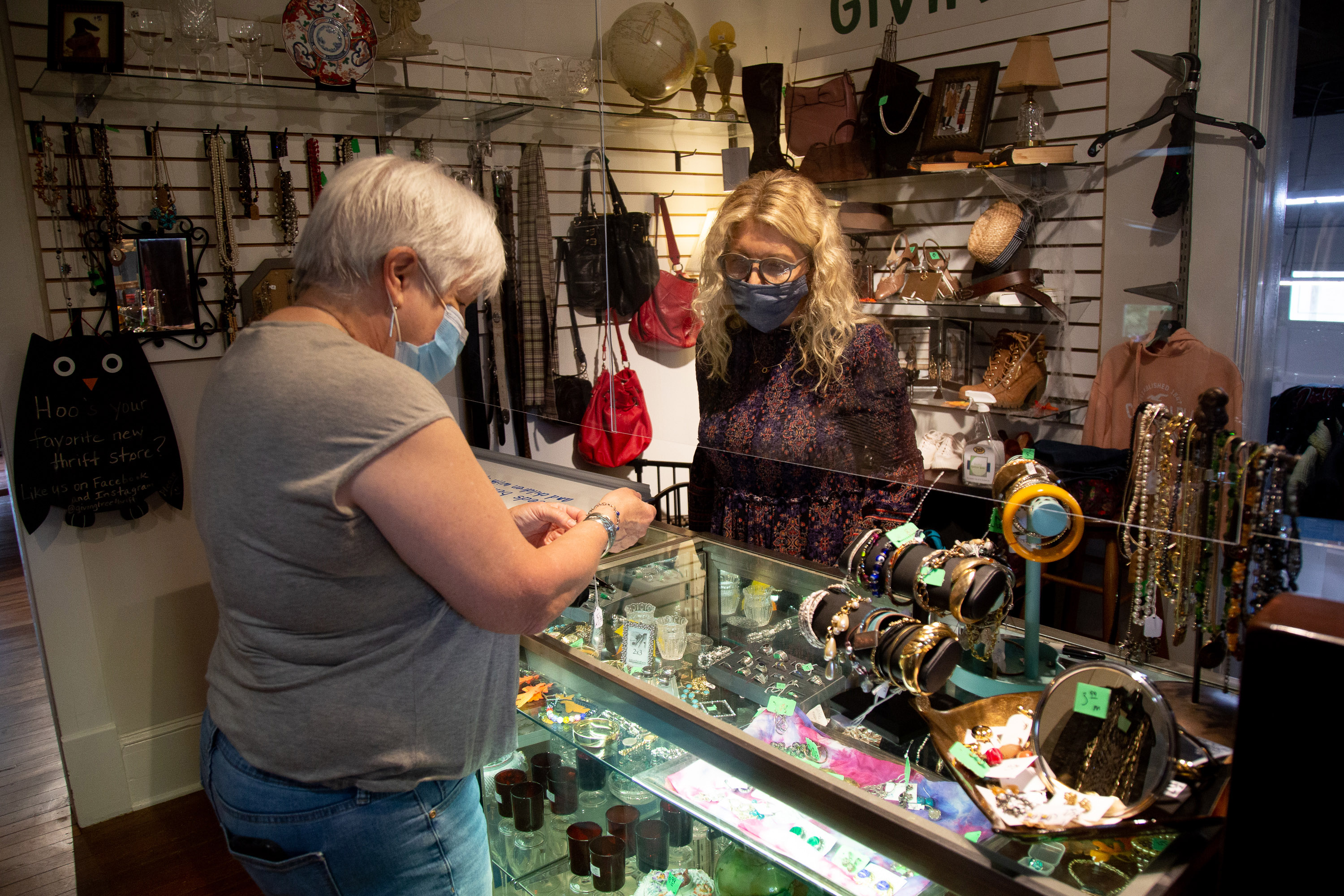 Karen Moore, (R), one of the officers at the Giving Tree Thrift Store in Chamblee, helps Karyl Boyd with a purchased Saturday, October 24, 2020. STEVE SCHAEFER / SPECIAL TO THE AJC