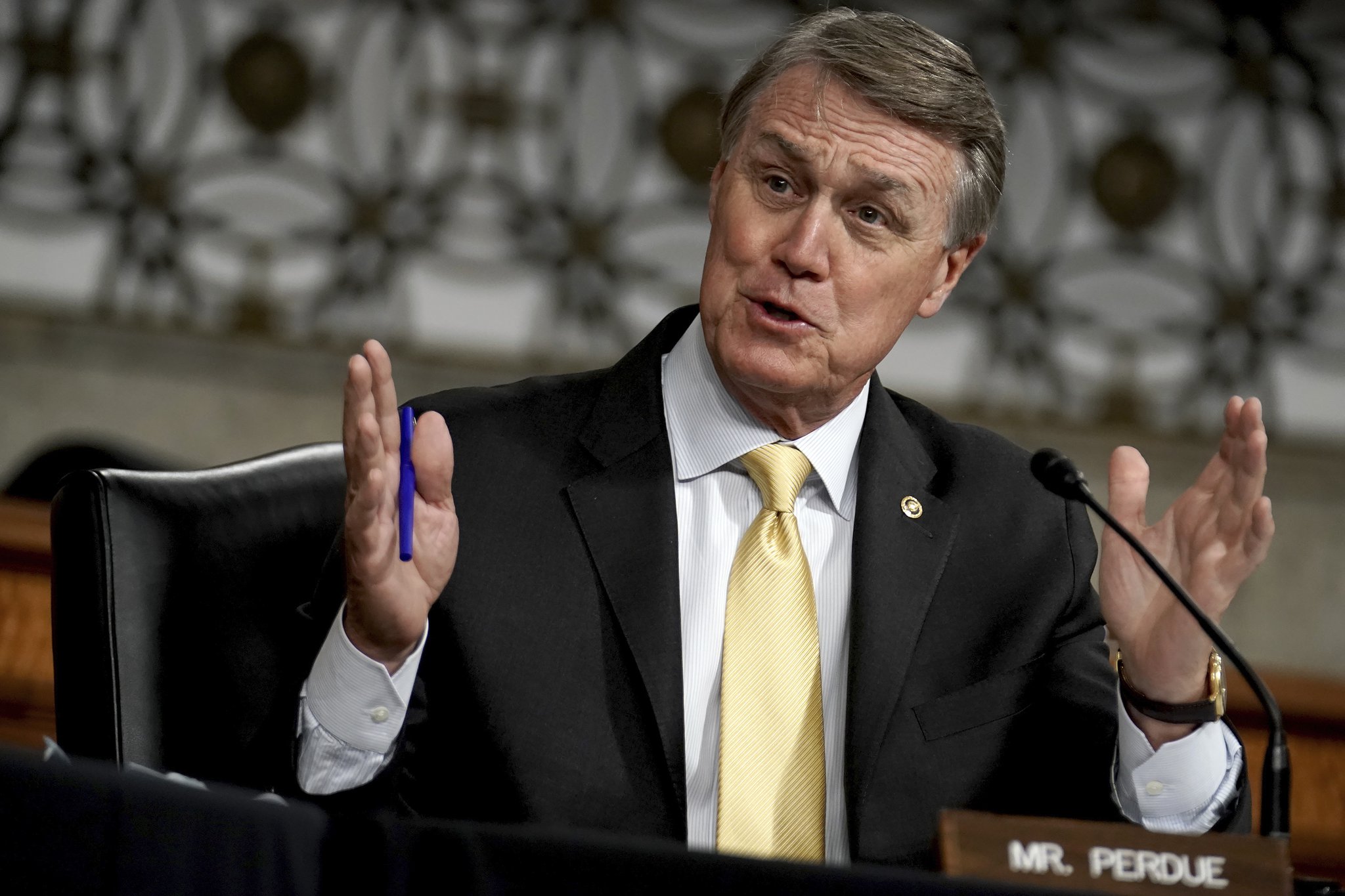 Sen. David Perdue, seen here in a May hearing, says in a recent ad he has been "totally exonerated" by the Senate Ethics Committee, the SEC and DOJ. Since then, however, questions over his stock trades have intensified. (Greg Nash/Pool via AP)