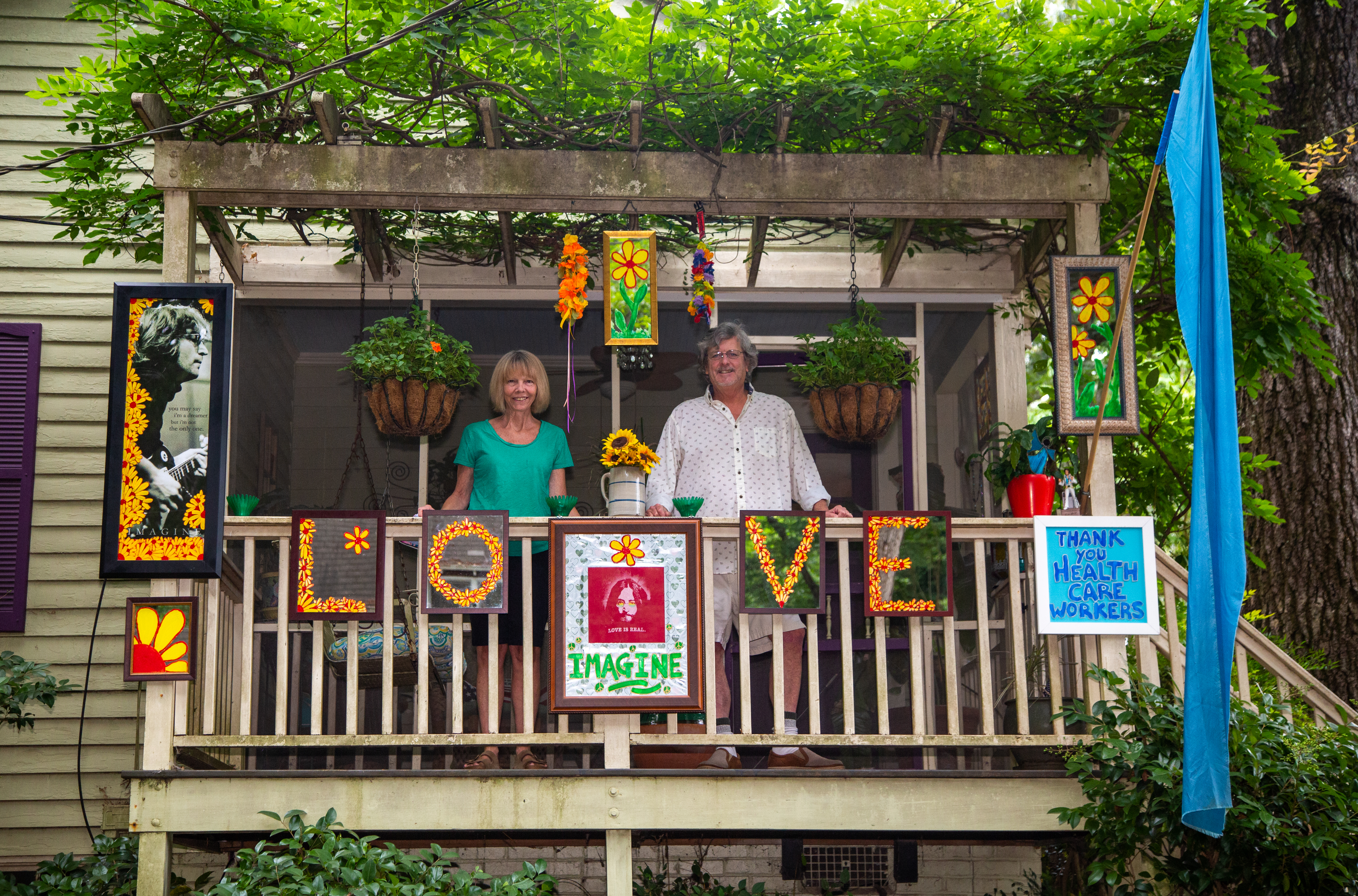 Drew and Valerie Matthews stand on the porch of their Ormewood home with their John Lennon "Love" art display they put up to cheer up their neighbors. They started their first of six different art displays during the first week of the pandemic quarantine in early April. They are donating their first display, featuring the "Mona Lisa," to the Atlanta History Center for a project on the pandemic. (Phil Skinner for The Atlanta Journal-Constitution)
