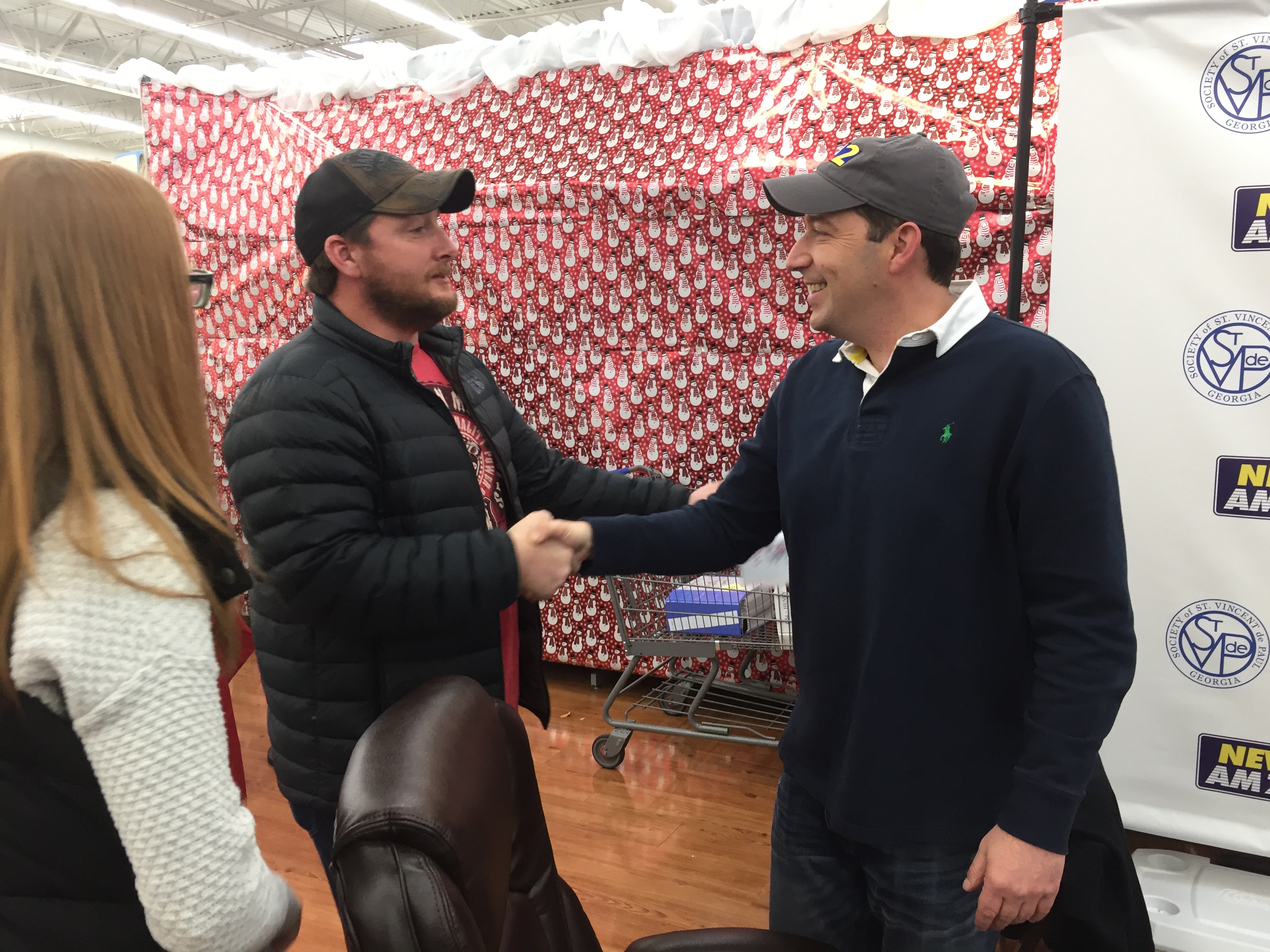 Erin Burch (left) used to work as a producer for Clark Howard's radio show. Mark Arum, talk show host and traffic guy, greets her husband Brock. CREDIT: Rodney Ho/ rho@ajc.com