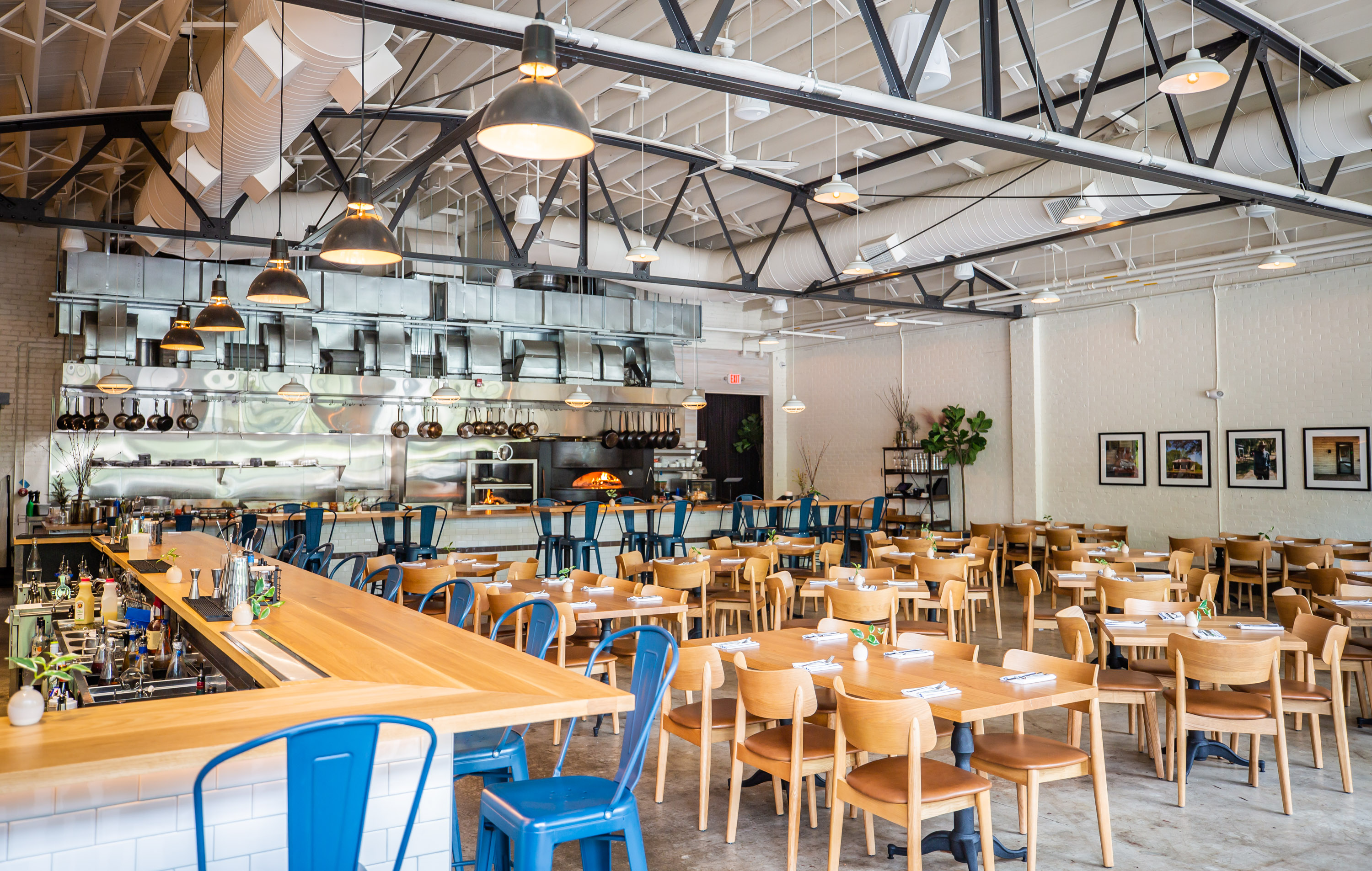Adele's industrial-style design includes an open interior, expansive ceiling with exposed ductwork, white brick walls, poured concrete flooring and retractable garage doors. Ryan Fleisher for The Atlanta Journal-Constitution
