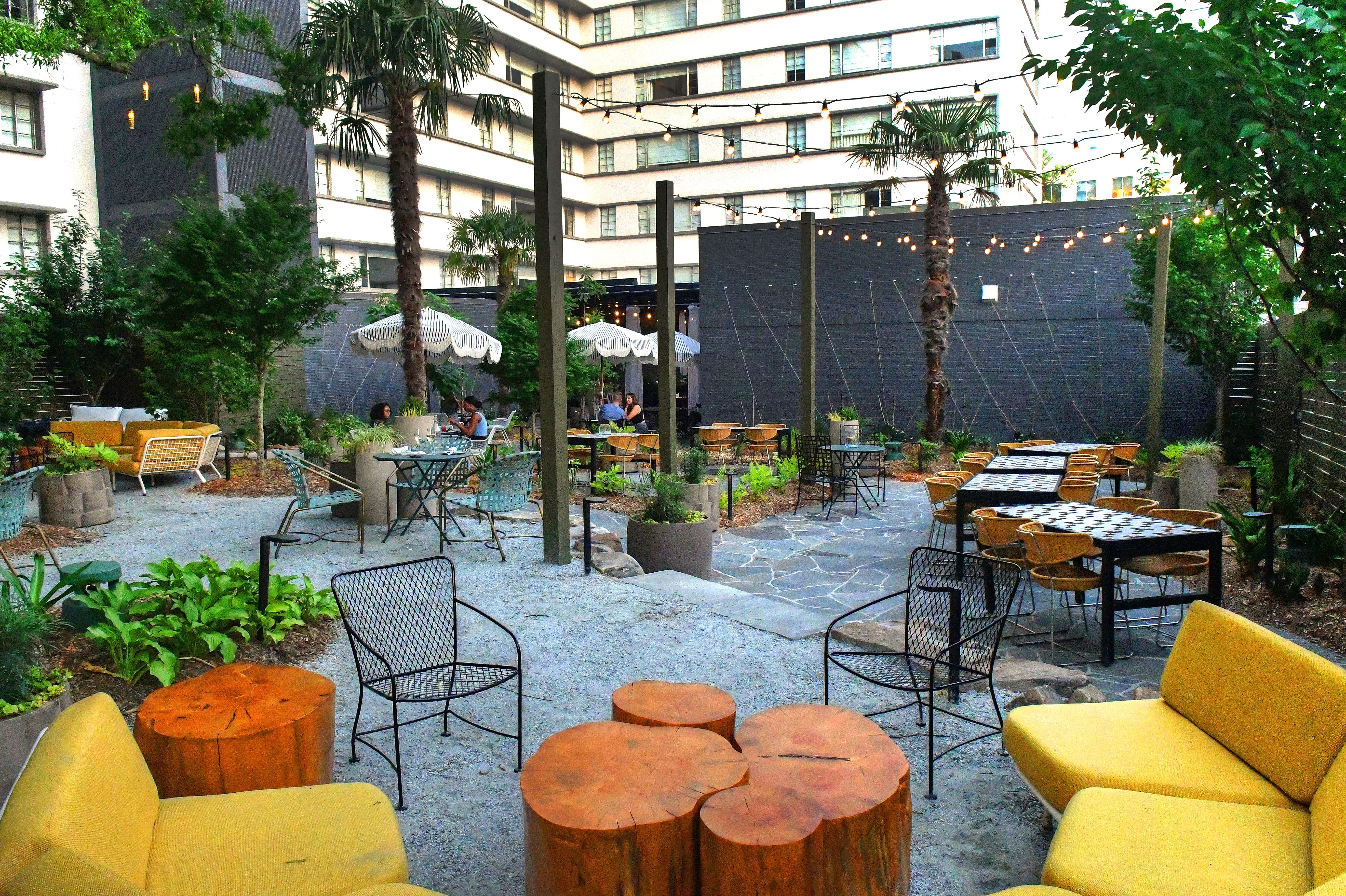 The open-air Willow Bar at the Kimpton Sylvan Hotel features a winding gravel path through soft seating choices underneath a canopy of old oak and palm trees. Chris Hunt for The Atlanta Journal-Constitution