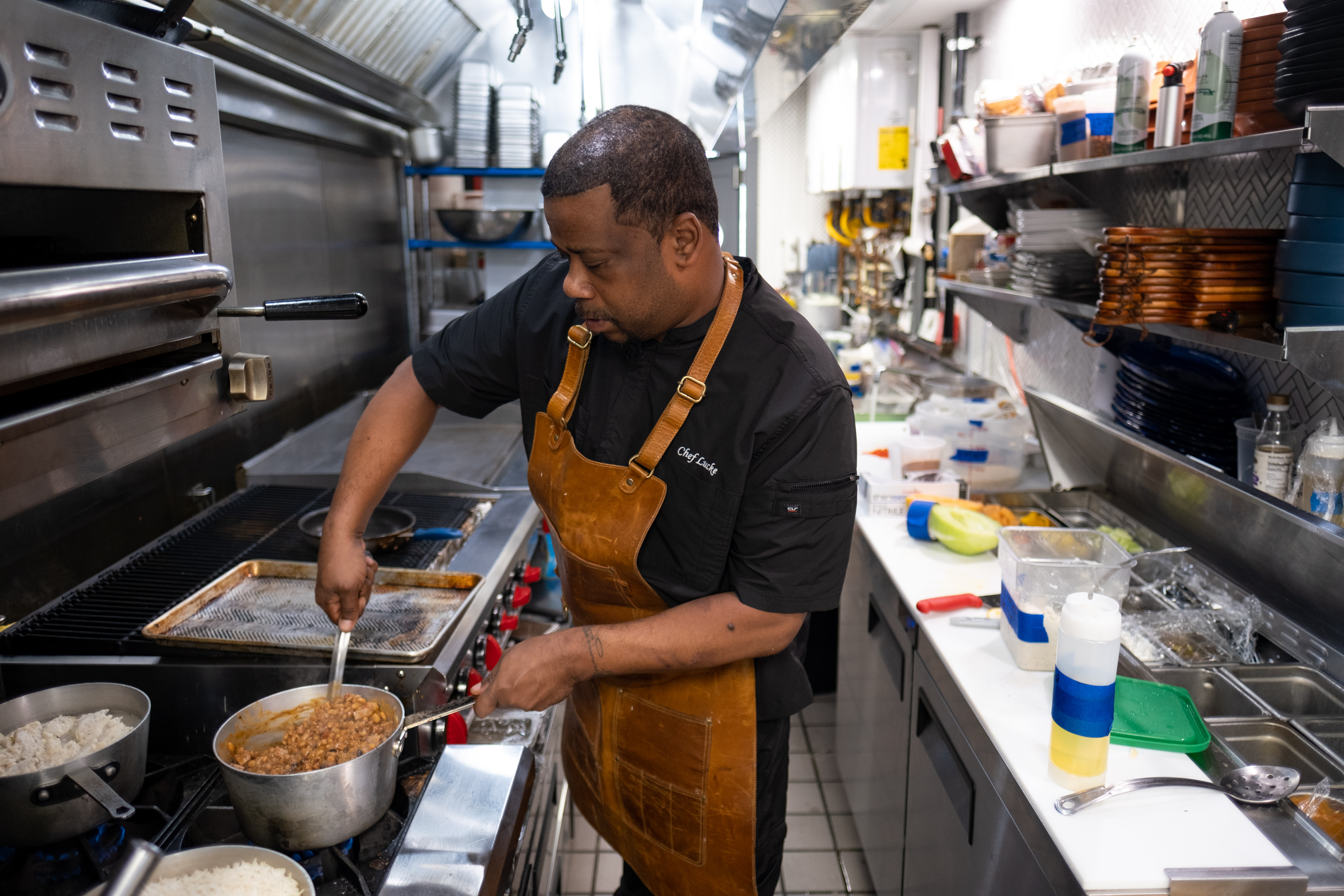 Executive Chef Christian “Lucke” Bell stirs beans for huevos rancheros in the kitchen of Oreatha’s at the Point. Ben Gray for the Atlanta Journal-Constitution