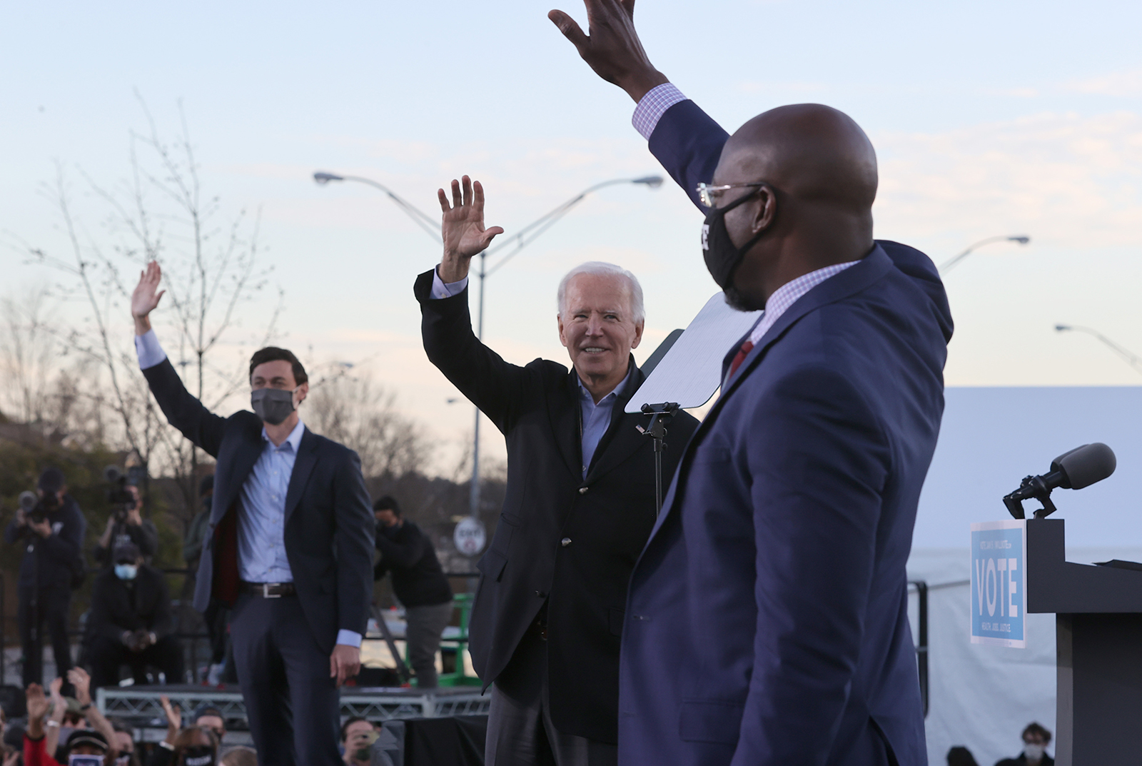 President-elect Joe Biden, center, along with democratic candidates for the U.S. Senate Jon Ossoff, left, and Rev. Raphael Warnock, greet supporters during a campaign rally the day before their runoff election in the parking lot of Centerparc Stadium on Monday, Jan. 4, 2021, in Atlanta, Georgia. (Chip Somodevilla/Getty Images/TNS)