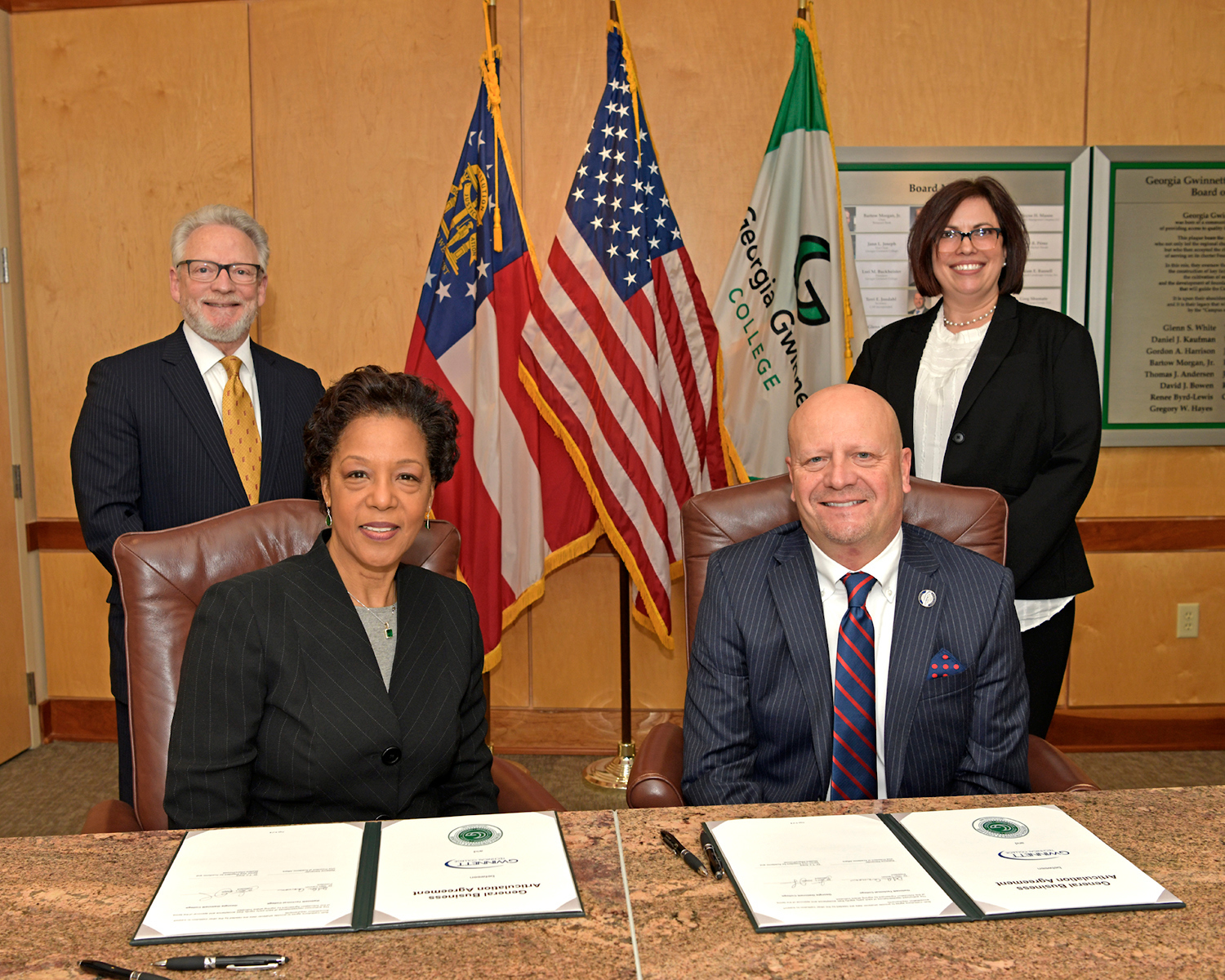Georgia Gwinnett College President Jann Joseph (seated, left) and Gwinnett Tech President D. Glen Cannon (seated, right) pose after signing an articulation agreement for students seeking to transfer credits from the technical school to GGC.
