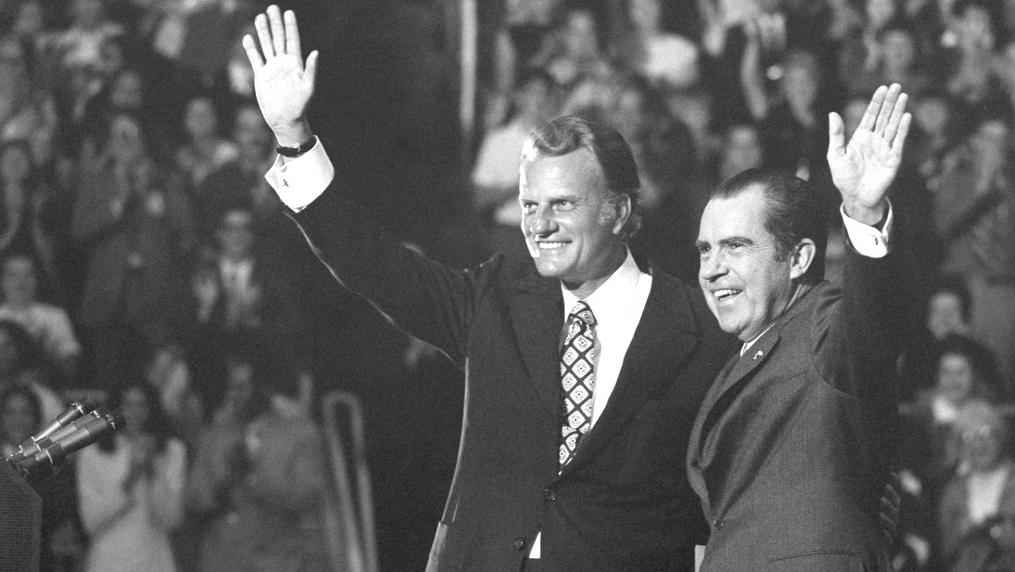 FILE - In this Oct. 16, 1971 file photo, Evangelist Billy Graham and President Nixon wave to a crowd of 12,500 at ceremonies honoring Graham at Charlotte, N.C. Graham, who transformed American religious life through his preaching and activism, becoming a counselor to presidents and the most widely heard Christian evangelist in history, has died. Spokesman Mark DeMoss says Graham, who long suffered from cancer, pneumonia and other ailments, died at his home in North Carolina on Wednesday, Feb. 21, 2018. He was 99. (AP Photo, File)