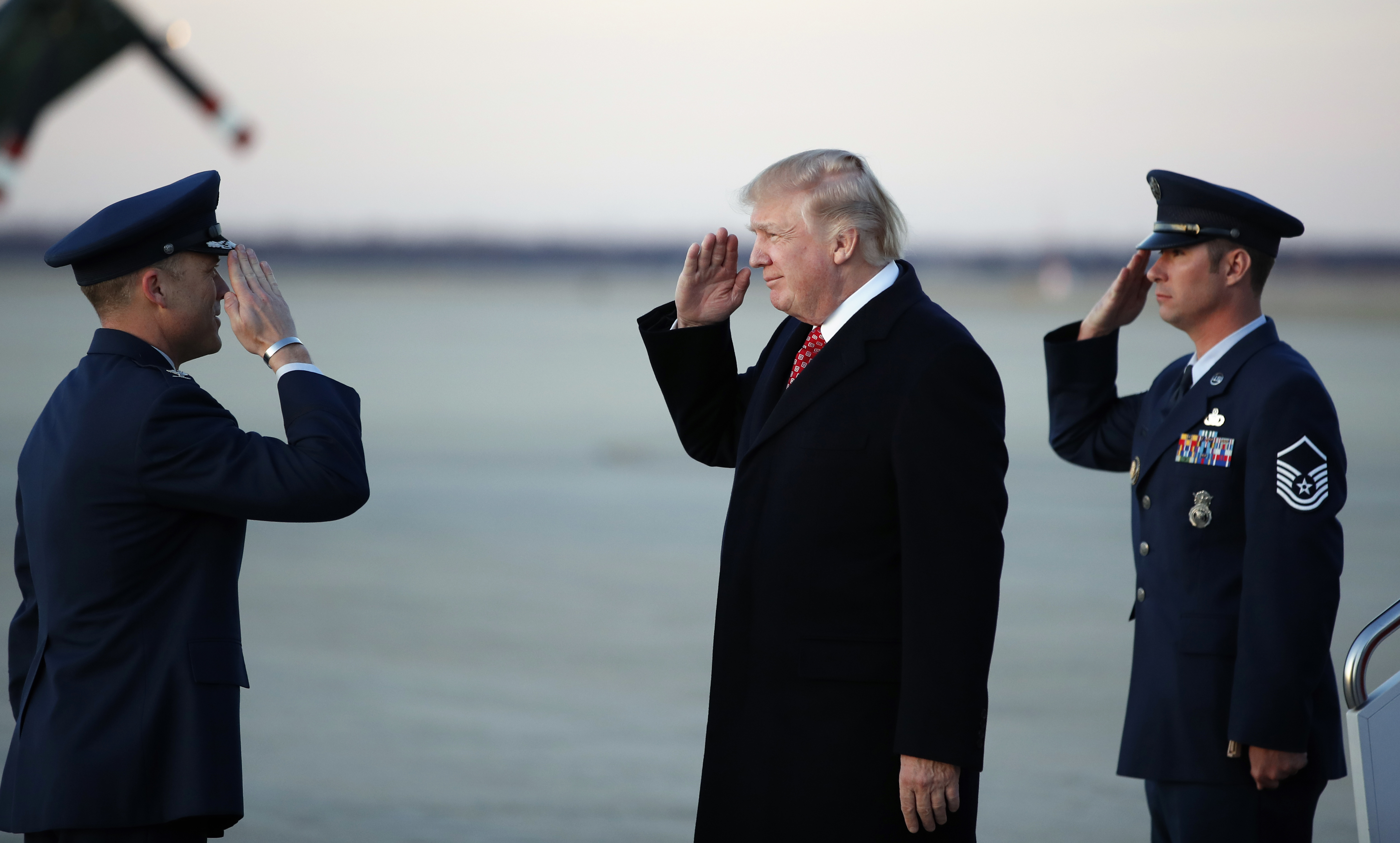 President Donald Trump salutes as he stands on the tarmac after disembarking Air Force One as he arrives Sunday, March 5, 2017, at Andrews Air Force Base, Md. Trump is returning from Mar-a-Largo, Fla. (AP Photo/Alex Brandon)