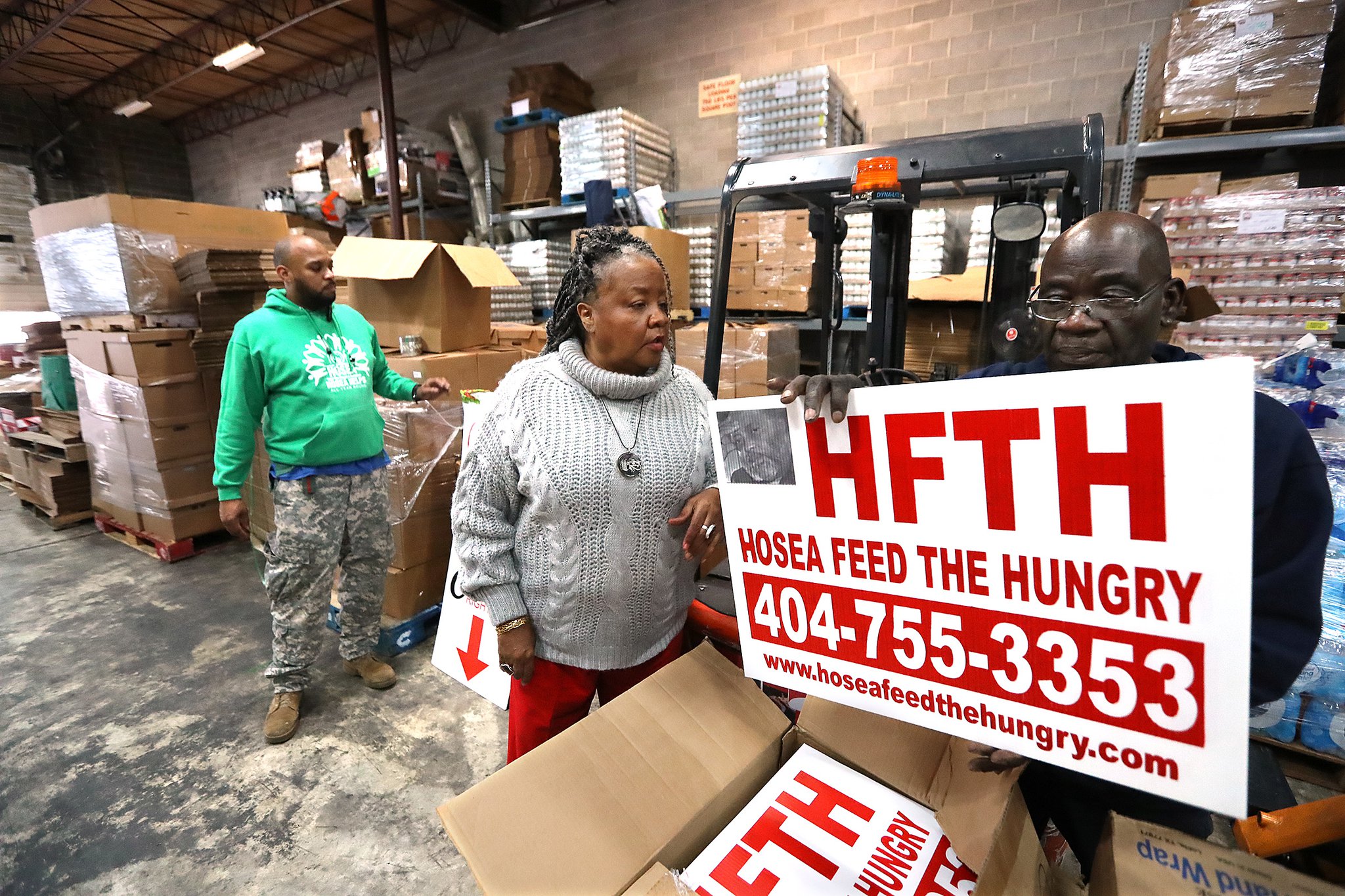 Hosea Williams III (from left), Hosea Feed the Hungry CEO Elisabeth Omilami, and Hopeton Gordon work at a rental warehouse while renovations were being made to the organization's existing location on Thursday, Jan. 16, 2020, in Atlanta. (Curtis Compton / ccompton@ajc.com)