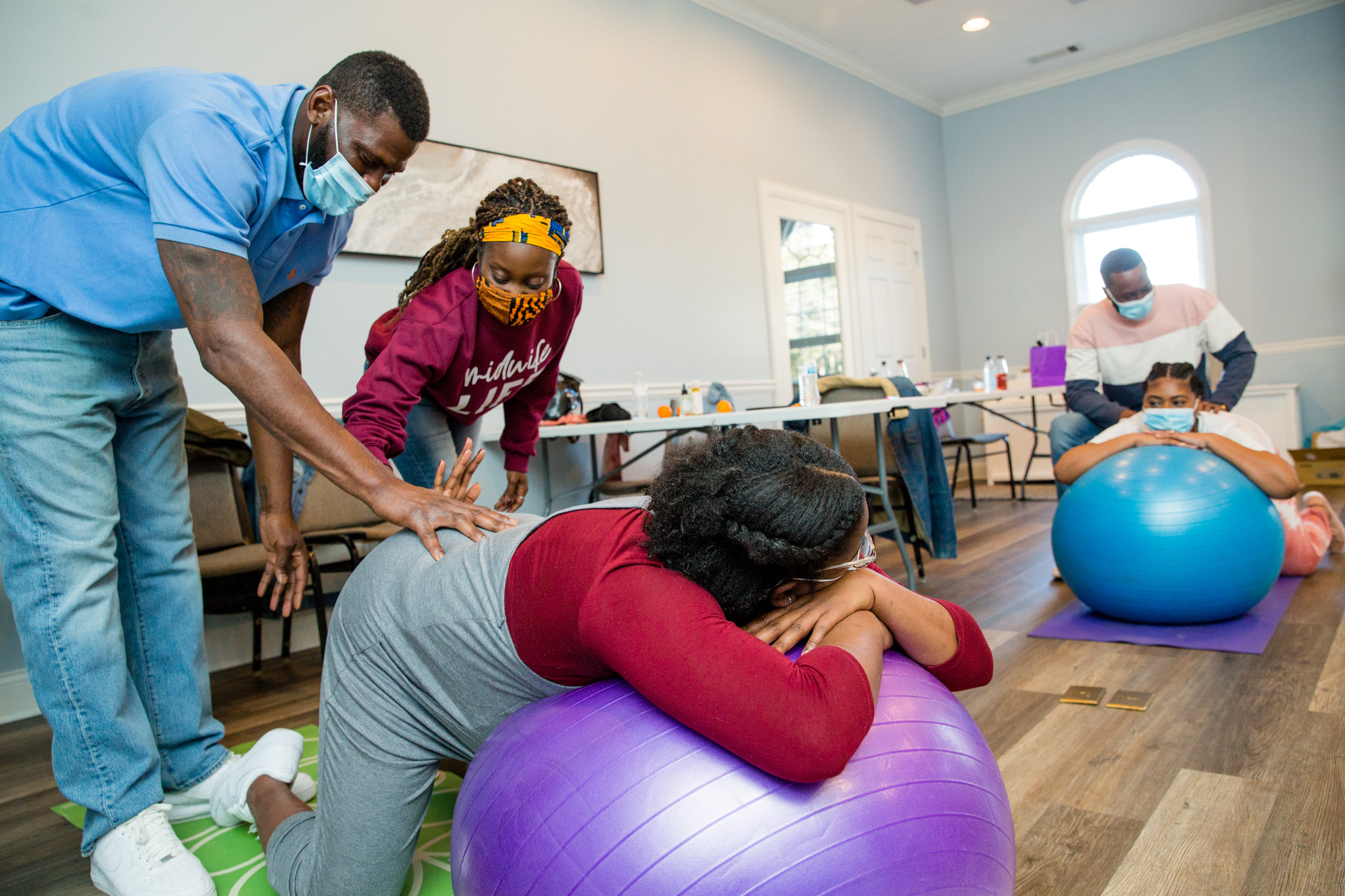 Birth by Grace Midwifery holds a class where Parish Munroe (left) is shown massage techniques by Christine Taylor on mother-to-be Kiah Munroe in Peachtree City on Saturday, Jan. 23, 2021. The families are planning home births under the guidance of Taylor, a certified nurse-midwife, and doula Dawn Hutcherson. (Jenni Girtman for The Atlanta Journal-Constitution)