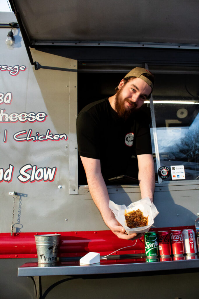 Levi Brock holds out a bowl of barbecue macaroni and cheese that he has just prepared on Feb. 16. in Woodstock, Georgia. (Sarah Swetlik/Fresh Take Georgia)
