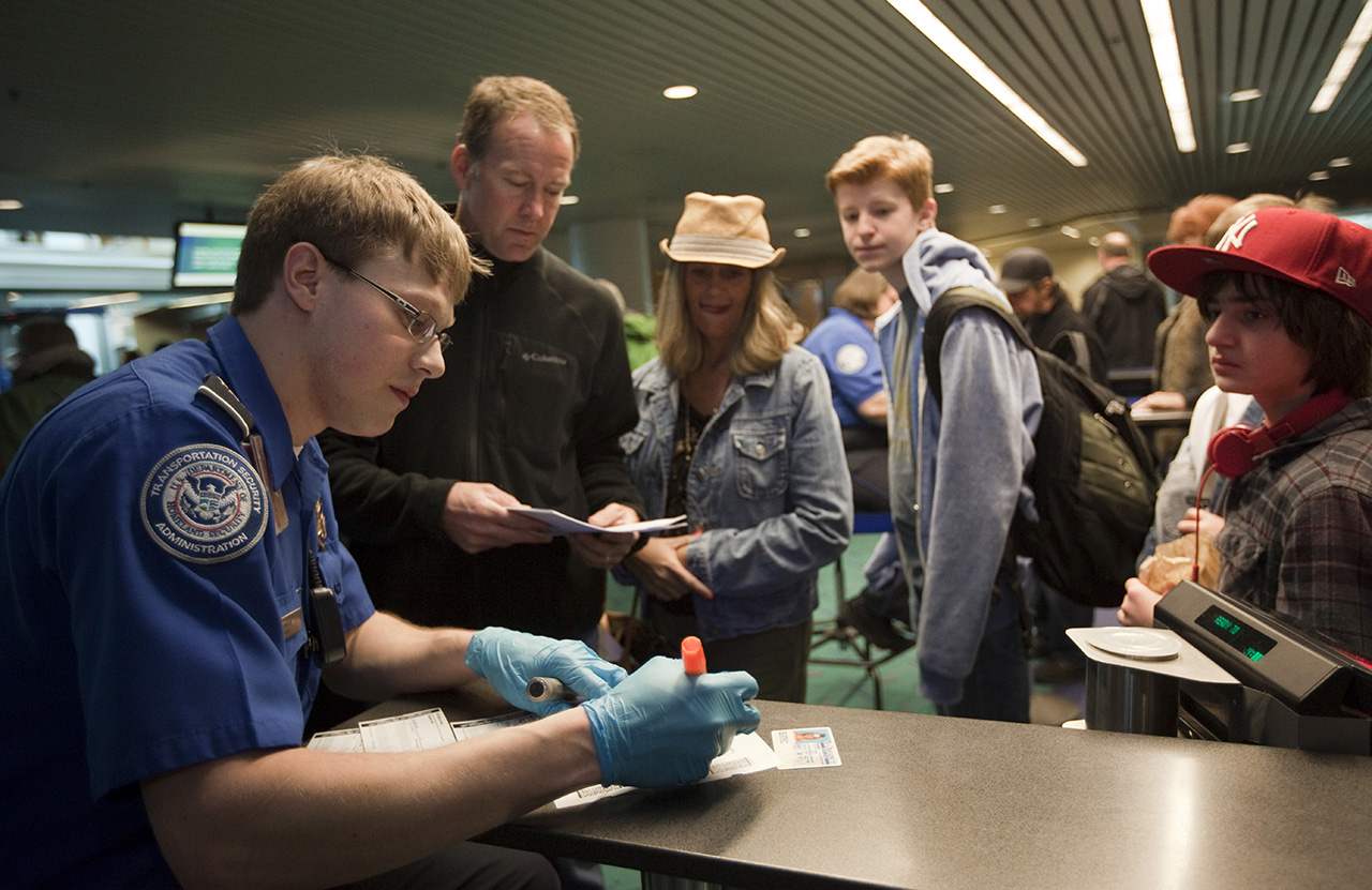 Passengers line up to a Transportation Security Administration (TSA) officer to go through airport security at Portland International Airport (PDX). (Photo by Natalie Behring/Getty Images)