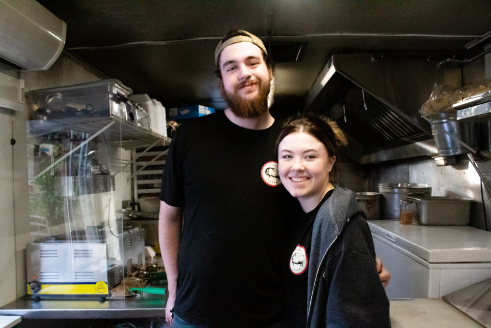 Levi Brock and Megan Eaves of Choate BBQ smile inside their food truck while serving in Woodstock, Georgia on Feb. 16. (Sarah Swetlik/Fresh Take Georgia)
