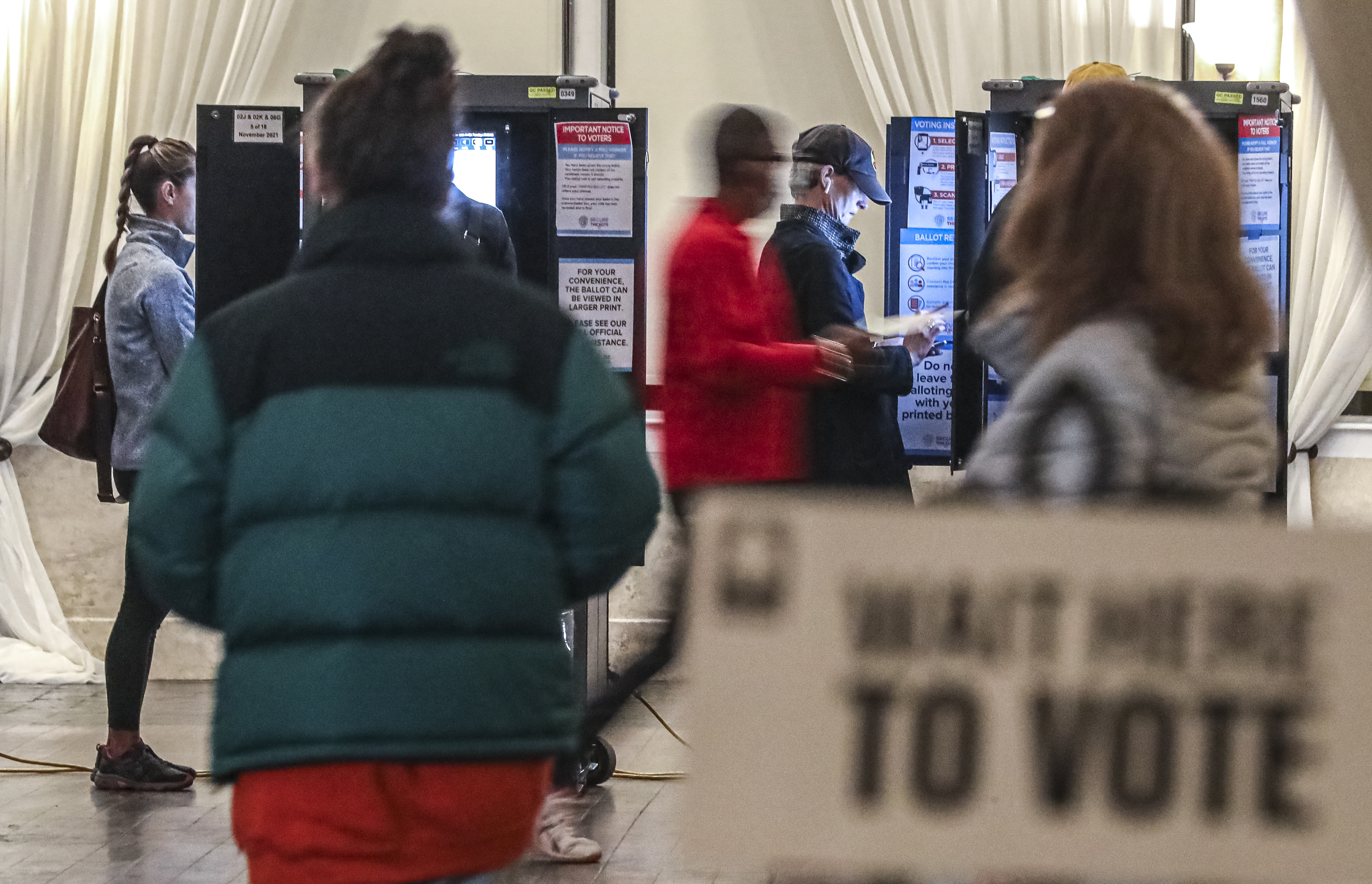 Voters surge to the voting machines first thing in the morning at Park Tavern in Atlanta on Nov. 2, 2021. (John Spink / John.Spink@ajc.com)