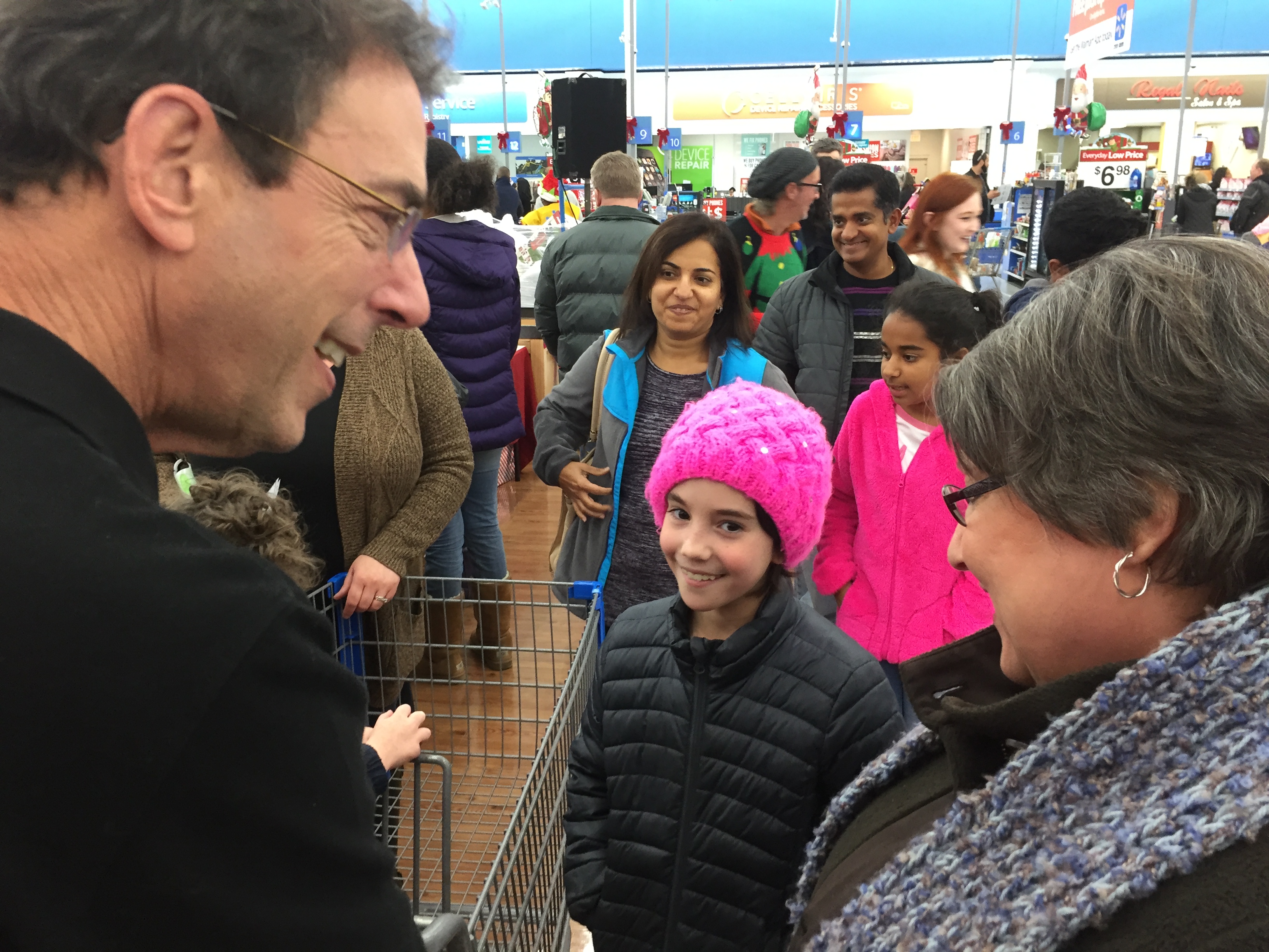 Clark Howard with Loraine Antonini and her grand-daughter Sadie, 9. "We came specifically for this," Loraine said. "Just to help make Christmas special." She selected gifts for at two-year-old named Tyson. Her daughter picked another nine year old girl. CREDIT: Rodney Ho/rho@ajc.com