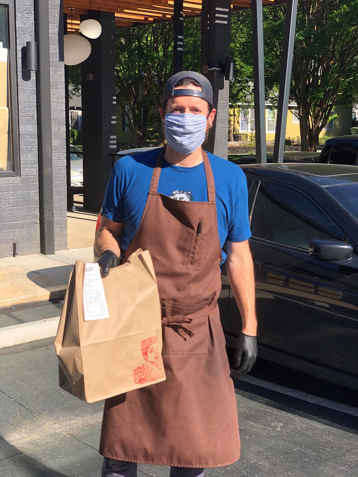 Talat Market co-owner and chef Rod Lassiter brings a meal to a customer’s car.