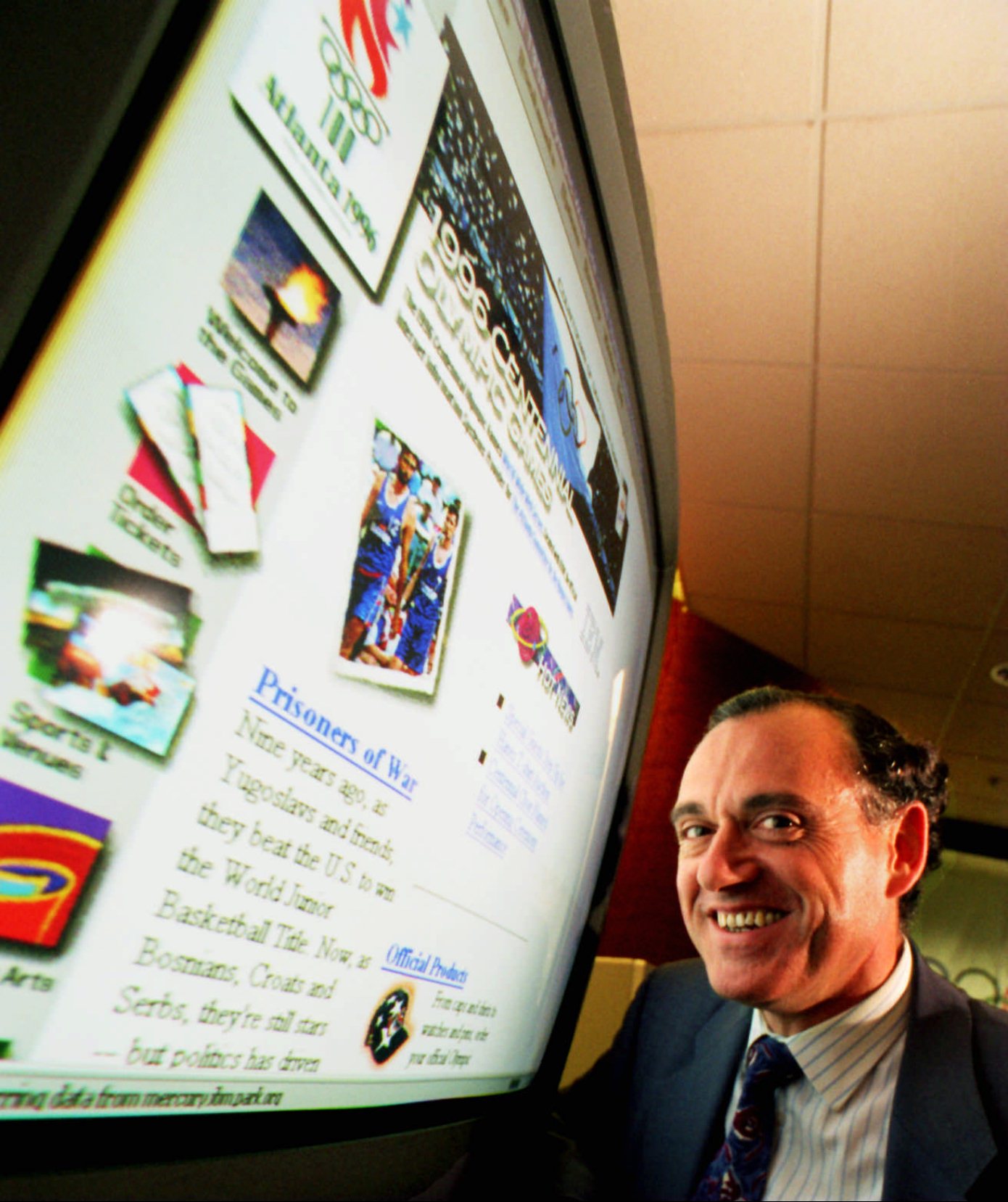Jose-Luis Iribarren poses in front of the ACOG website developed by IBM in 1996. “We kept adding things along the way,” said Iribarren recently. “I don’t even know how did we manage to get to launch the website in time.” (Joey Ivansco / AJC file)