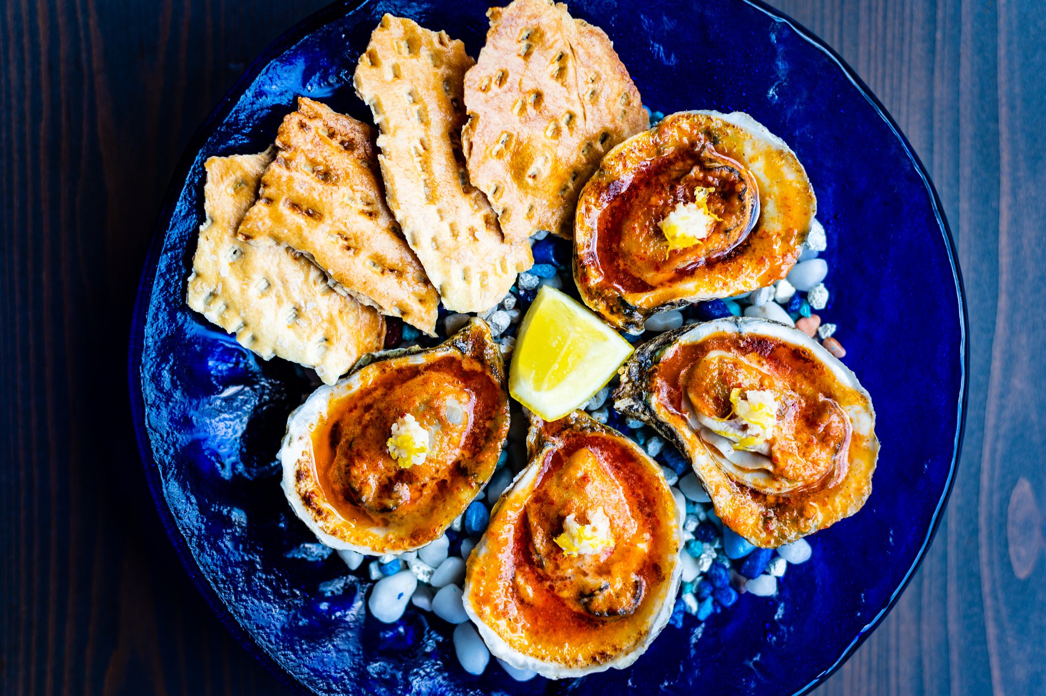 Roasted oysters with Calabrian chiles and saltines at Cold Beer. CONTRIBUTED BY HENRI HOLLIS