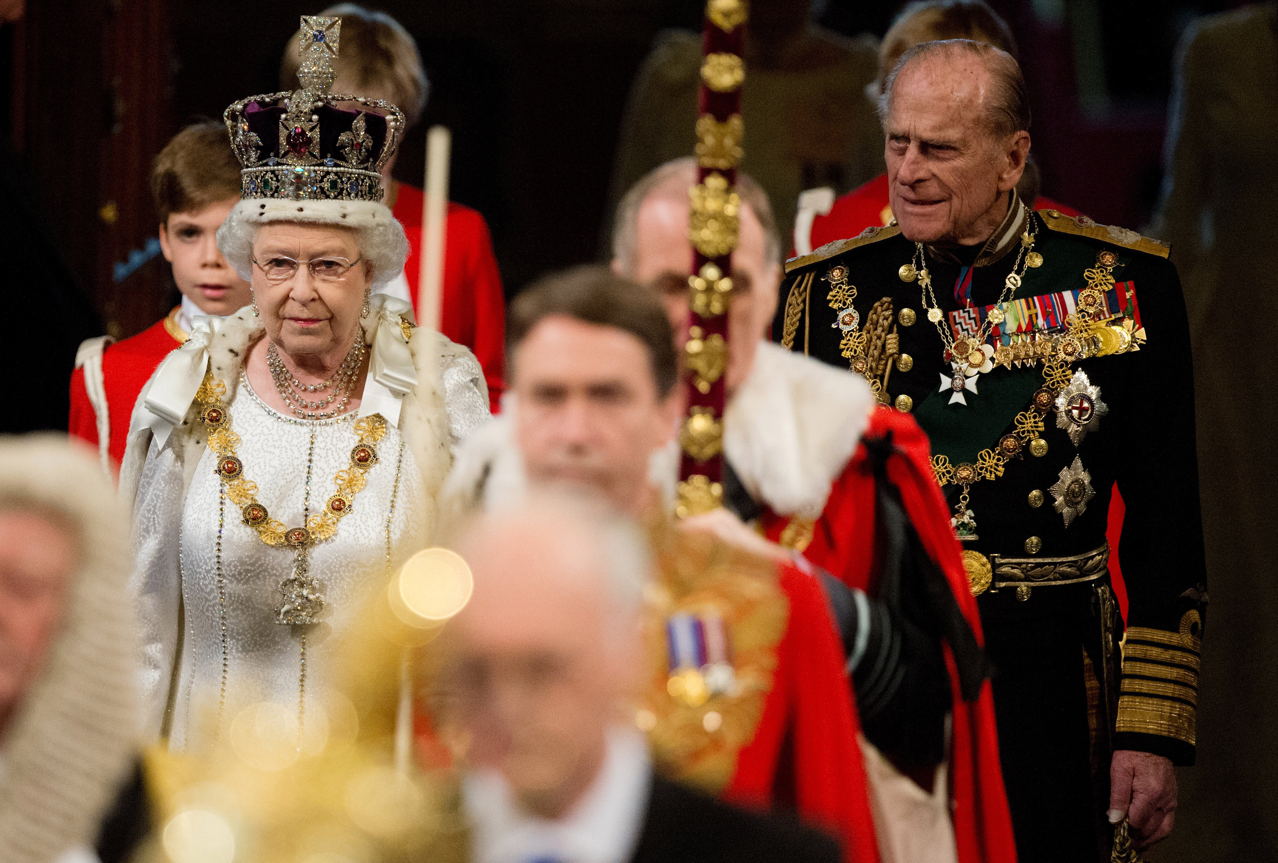 LONDON, ENGLAND - MAY 09: Queen Elizabeth II, wearing the Imperial State Crown, and Prince Philip, Duke of Edinburgh proceed through the Royal Gallery in the Palace of Westminster during the State Opening of Parliament on May 9, 2012 in London, England. Queen Elizabeth II unveiled the coalition government's legislative programme in a speech delivered to Members of Parliament and Peers in The House of Lords. New legislation is expected to be introduced on banking reform, House of Lords reform, changes to public sector pensions and plans for increased internet monitoring. (Photo by Leon Neal - WPA Pool/Getty Images)
