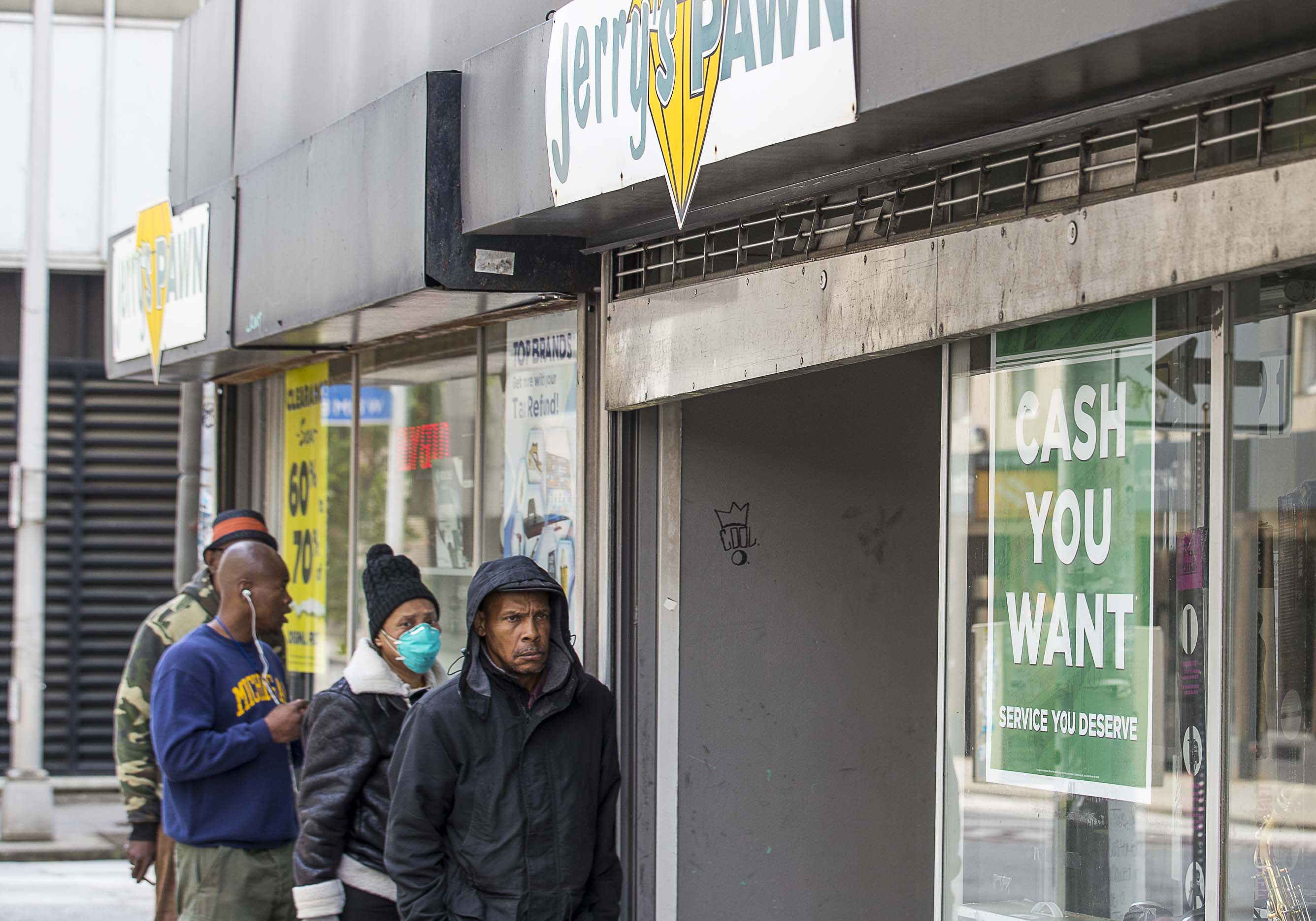 People wait outside Jerry’s Pawn in order to sell or buy items at the downtown Atlanta pawn shop on Wednesday, April 1, 2020. The shop, located on Decatur Street SE, was only allowing two customers in at a time. (ALYSSA POINTER / ALYSSA.POINTER@AJC.COM)