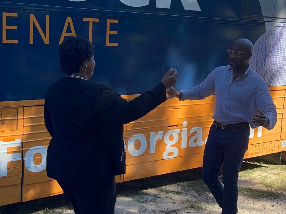 Democratic gubernatorial candidate Stacey Abrams and US Senator Raphael Warnock prepare for a hug at a campaign event in Cobb County on Wednesday. 