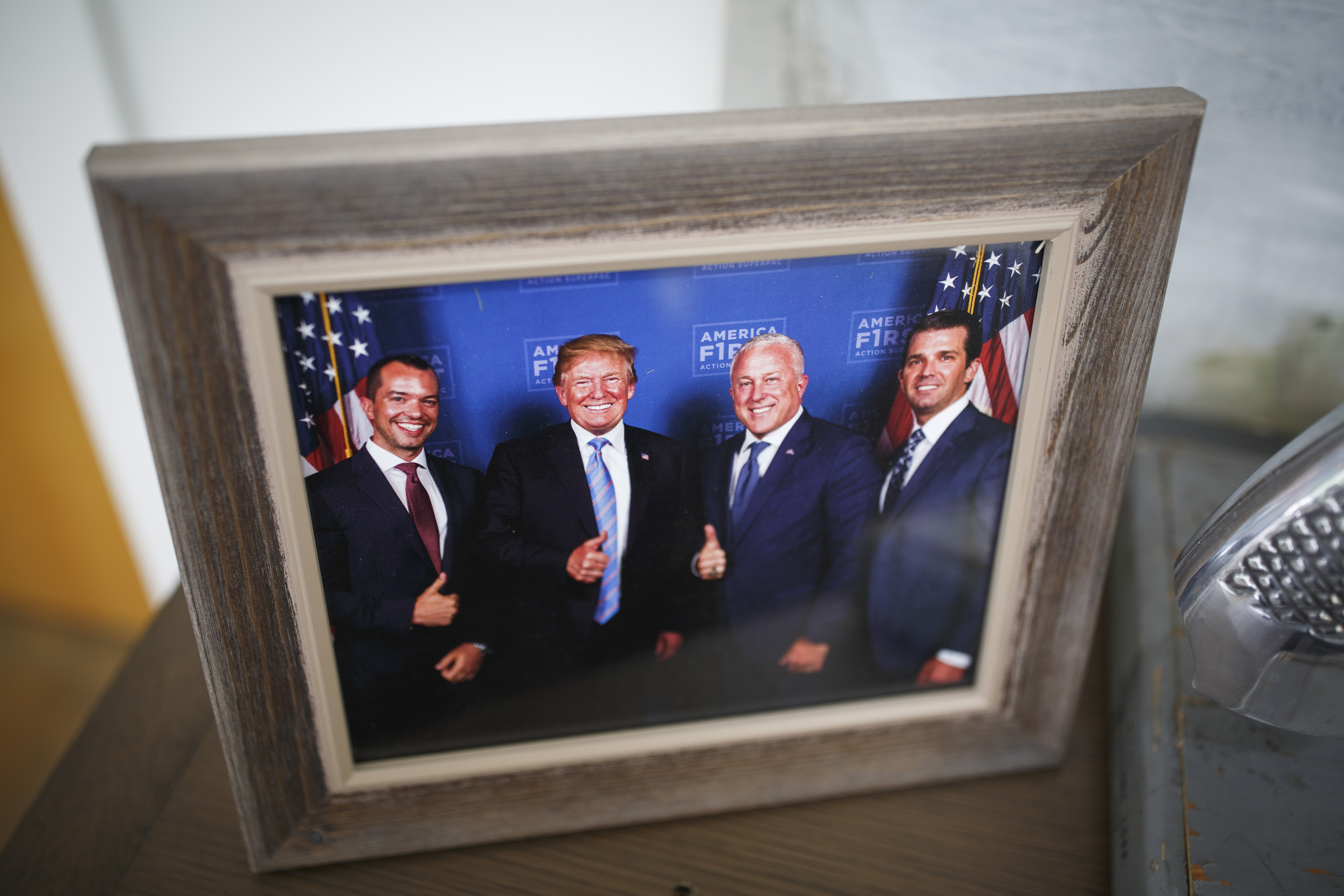 A photo of Bryan Eure and Bill White with President Donald Trump and his son Donald Trump Jr. is displayed in the couple’s home in the Paces neighborhood. Formerly a Hillary Clinton supporter, White says, “I don’t have any political allegiance to anybody, so I can’t shift anything that I’m not allegiant to.” (Melissa Golden/The New York Times)