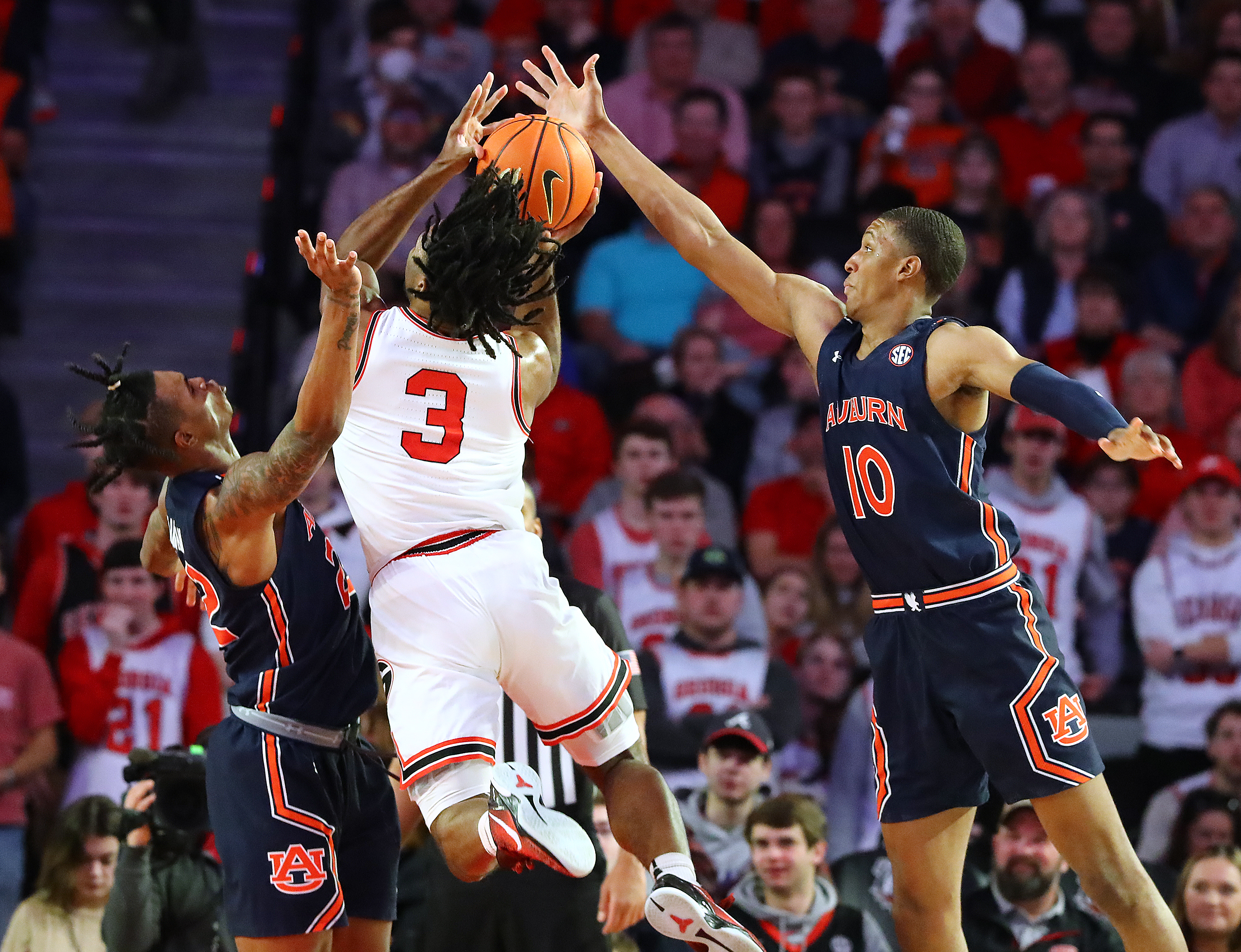 Georgia 's Kario Oquendo has his shot blocked by Auburn defender Jabari Smith (right) as he goes to the basket in a NCAA college basketball game on Saturday, Feb. 5, 2022, in Athens. “Curtis Compton / Curtis.Compton@ajc.com”`