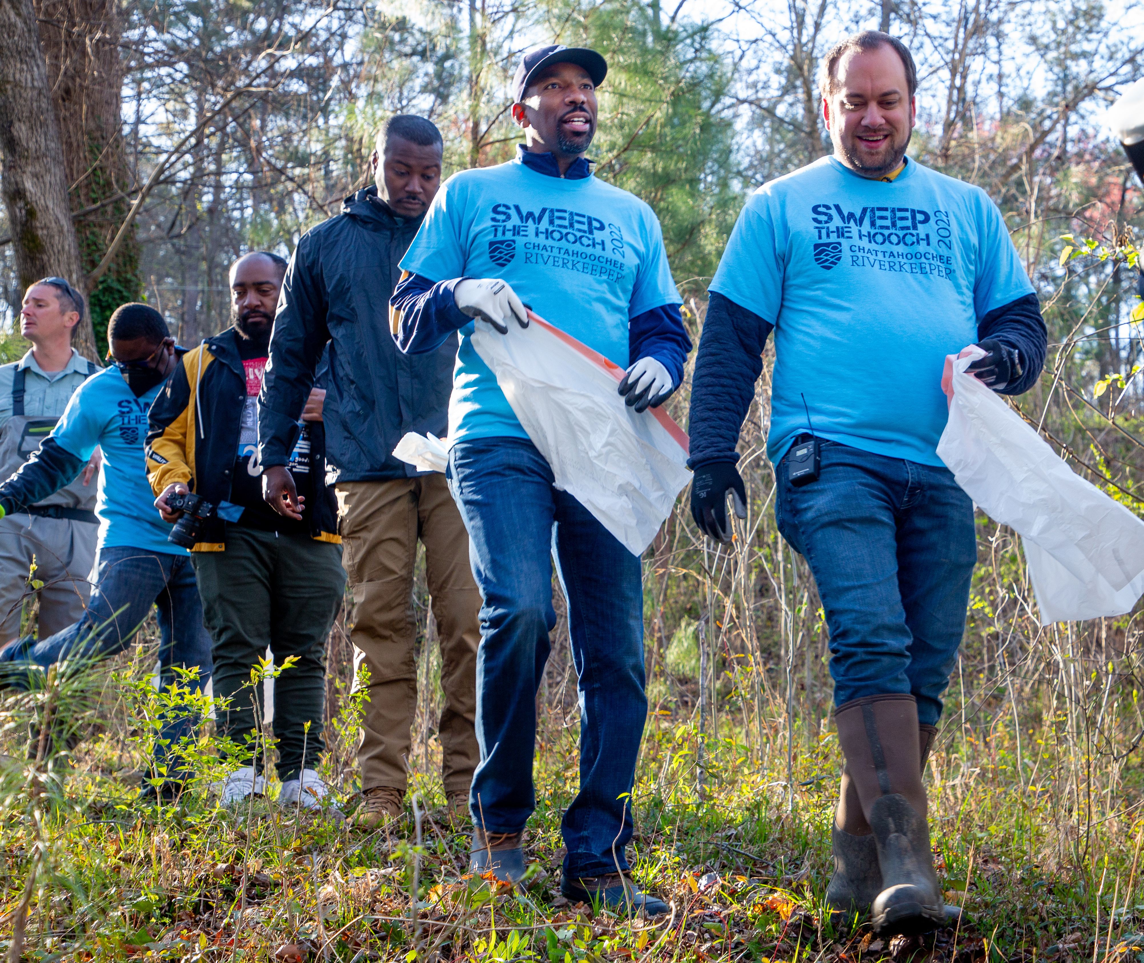 Atlanta Councilmember Dustin Hillis (right) and Mayor of Atlanta Andre Dickens (Center) head for the river with the other volunteers at the start of Sweep The Hooch day at Proctor Creek at Grove Park Saturday, March 26, 2022. Proctor Creek runs through Atlanta and ultimately empties into the Chattahoochee River. STEVE SCHAEFER FOR THE ATLANTA JOURNAL-CONSTITUTION