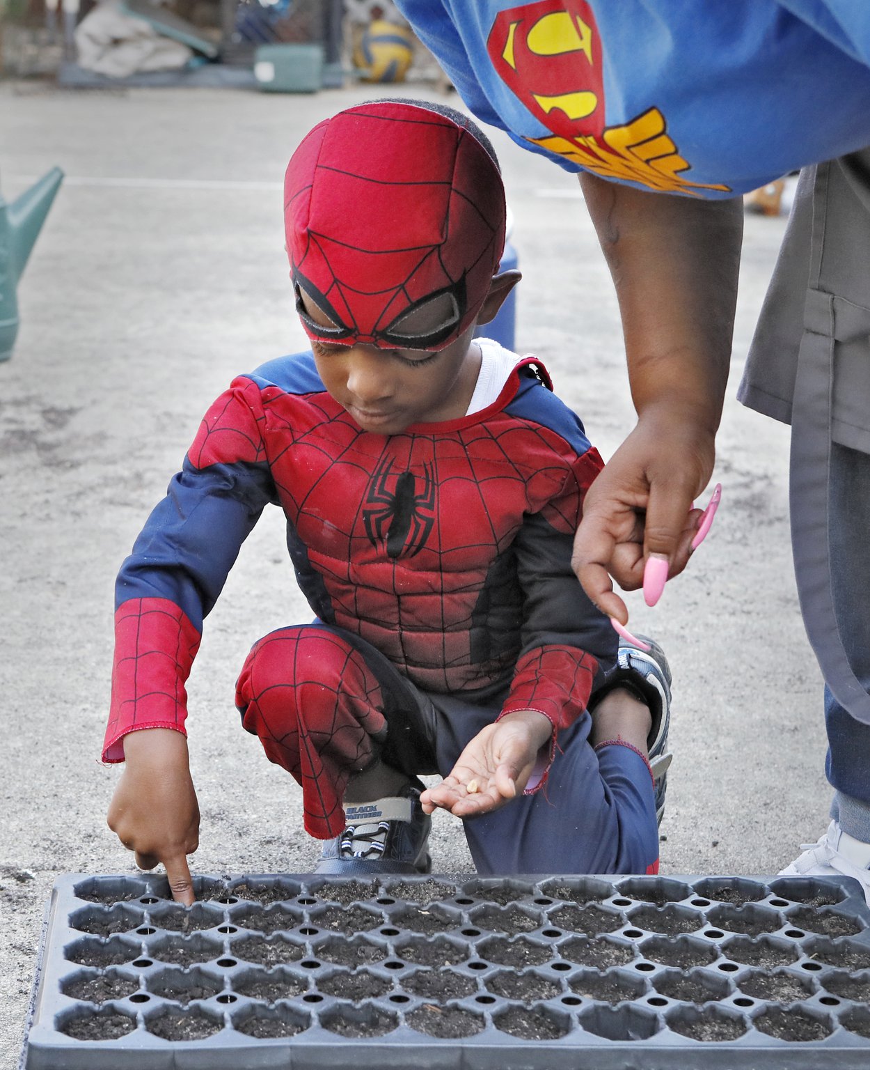 Teacher Danielle Brown helps Judah Manning, 4, plant seeds in the school garden at Little Ones Learning Center in Forest Park on Sept. 11, 2019.